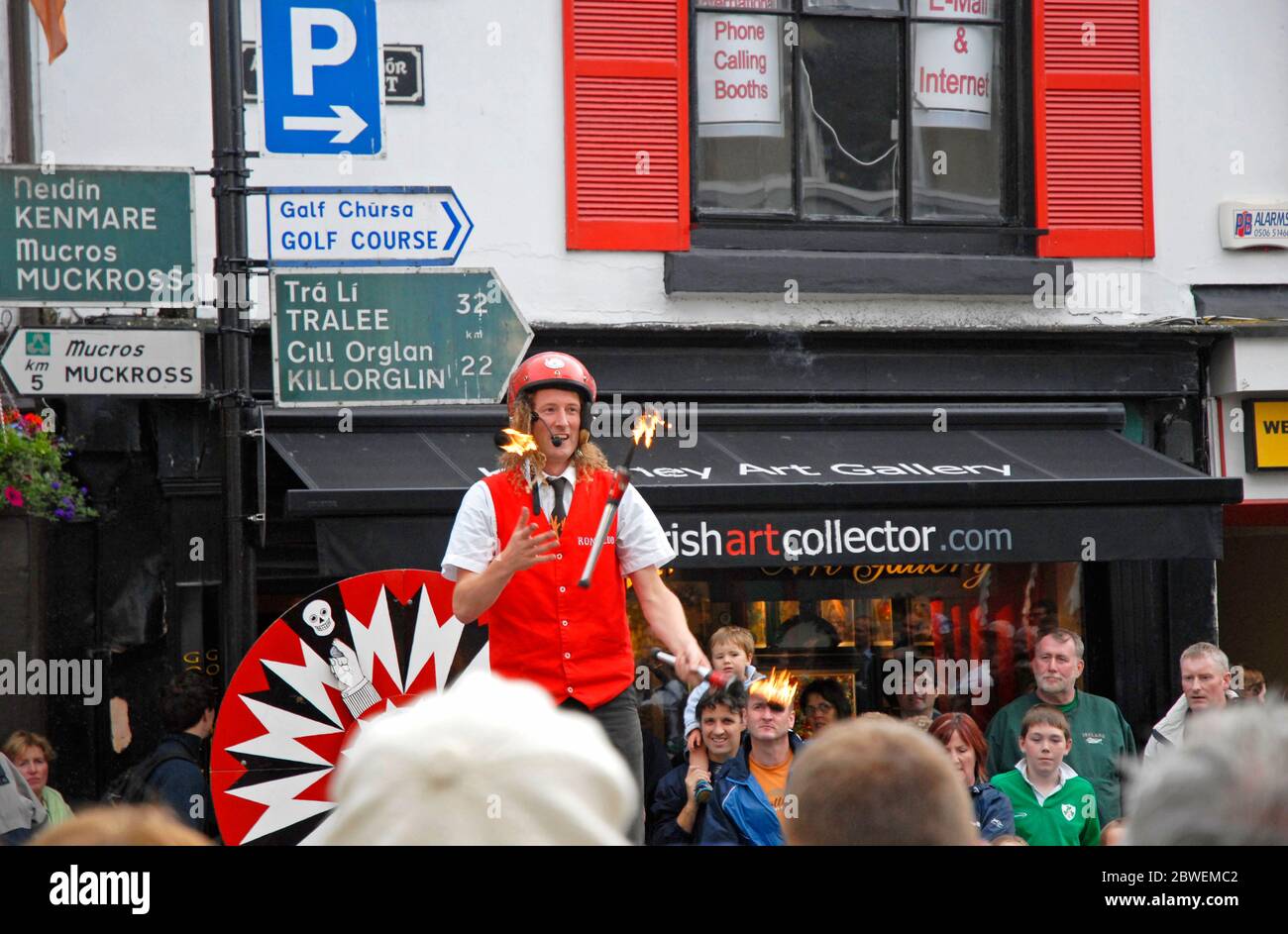 Street Entertainer: Crowd Watching Jongleur mit drei brennenden Fackeln, Killarney, Kerry, Republik Irland Stockfoto