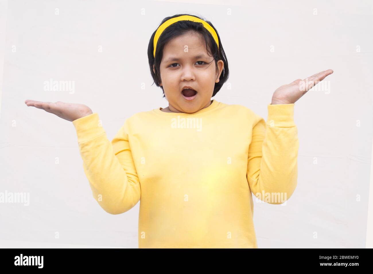 Porträt Von Mädchen Mit Armen Angehoben, Während Sie Gegen Weißen Hintergrund Stehen Stockfoto