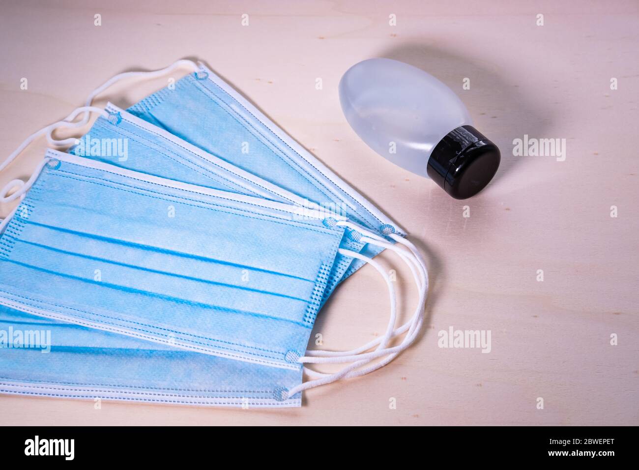 Chirurgie Gesichtsmasken und Hand Satnitierer Gel auf Holzhintergrund. Elemente zur Verhinderung von Coronavirus. Covid-19. Nahaufnahme. Stockfoto