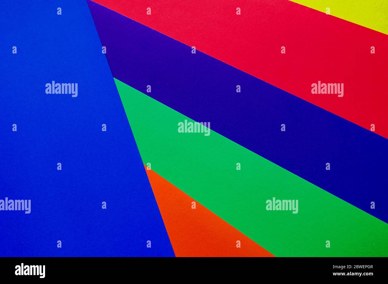 Mehrfarbiger Papierhintergrund. Papierbögen in Regenbogenfarben Nahaufnahme. Geometrischer Multitasking-Hintergrund. Platz für Text. Blick von oben. Stockfoto