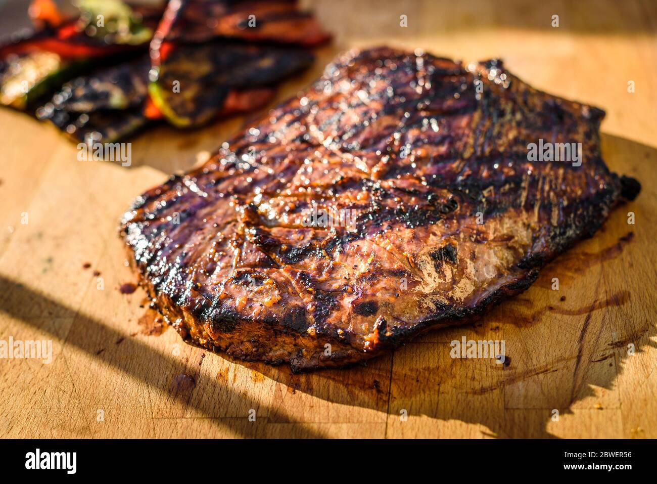 Saftig gegrillte marinierte Angus Beef Flank Steak auf Holzbrett. Fertige saftige medium Fleisch ruht, bevor es geschnitten ist und in Scheiben geschnitten. Stockfoto