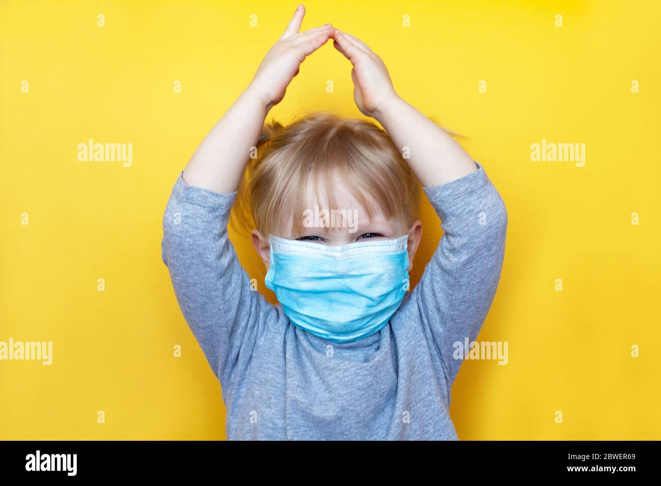 Kleines aukasisches Mädchen mit Schutzmaske. Konzept Isolierung zu Hause zu helfen, Coronavirus Covid-19 und Umweltschutz zu stoppen Stockfoto