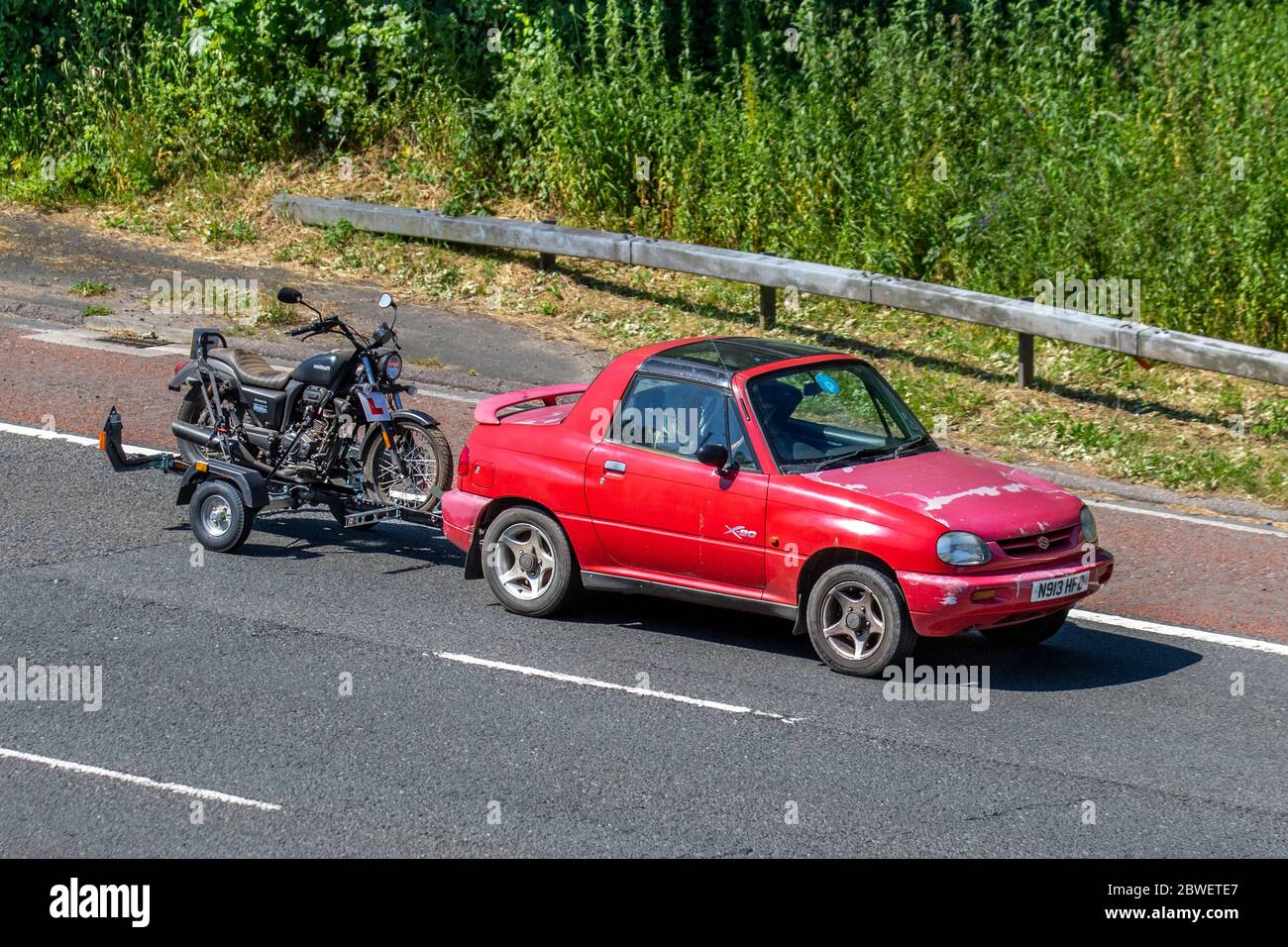 1996 90s roter Suzuki X-90 4WD Zweisitzer-SUV; Motorradfahrer; zweirädriger Transport, Motorräder, Abschleppen von Fahrzeugen Sinnis Hoodlum, Straßen, Oldtimer-Motorräder, klassische Fahrradfahrer, die auf der Autobahn M6 Chorley, Großbritannien, fahren Stockfoto