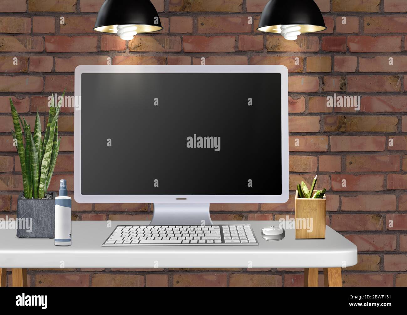 Moderner Schreibtisch mit Monitor-Tastatur Stifte und Pflanze Stockfoto