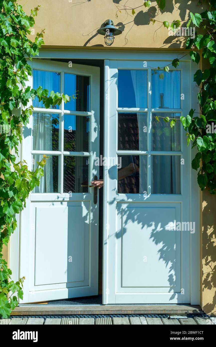 Öffnen Sie die weiße französische Haustür des Familienhauses und der Hand Stockfoto