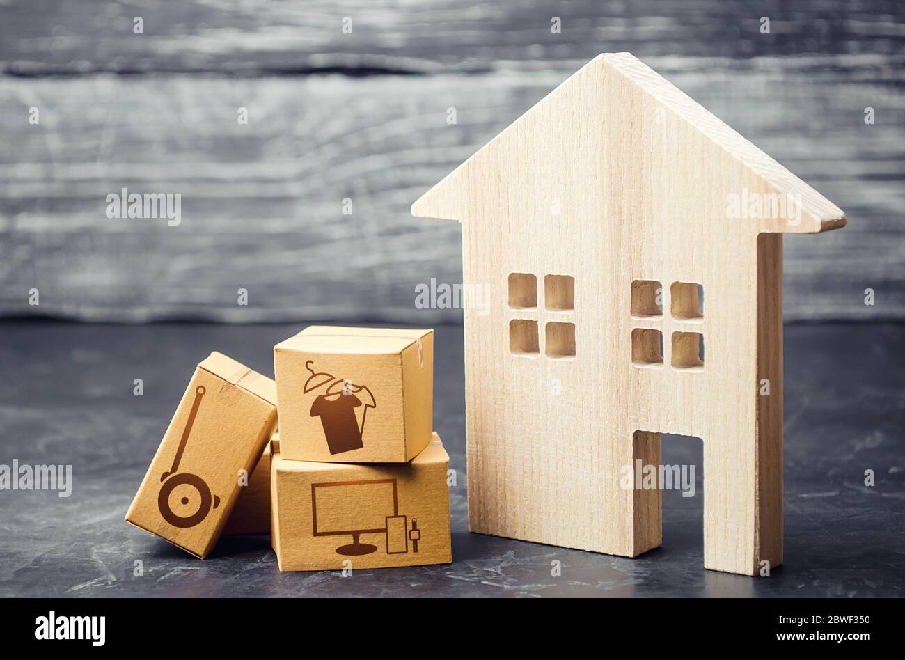 Haus und Kisten mit gelieferten bestellten Waren. Neuausrichtung des Geschäfts auf Online-Services und Netzwerkverkäufe. Bequeme und schnelle Lieferung des Kaufs Stockfoto