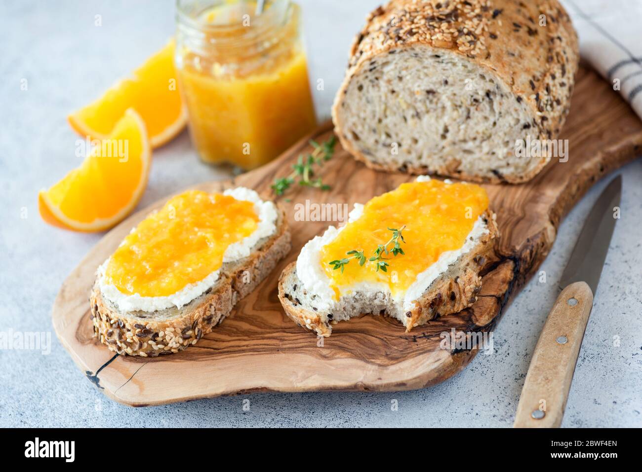 Gesundes Frühstück Toast mit Ricotta und Orangenmarmelade. Vollkornbrot mit frischem Weißkäse und süßer Orangenmarmelade Stockfoto