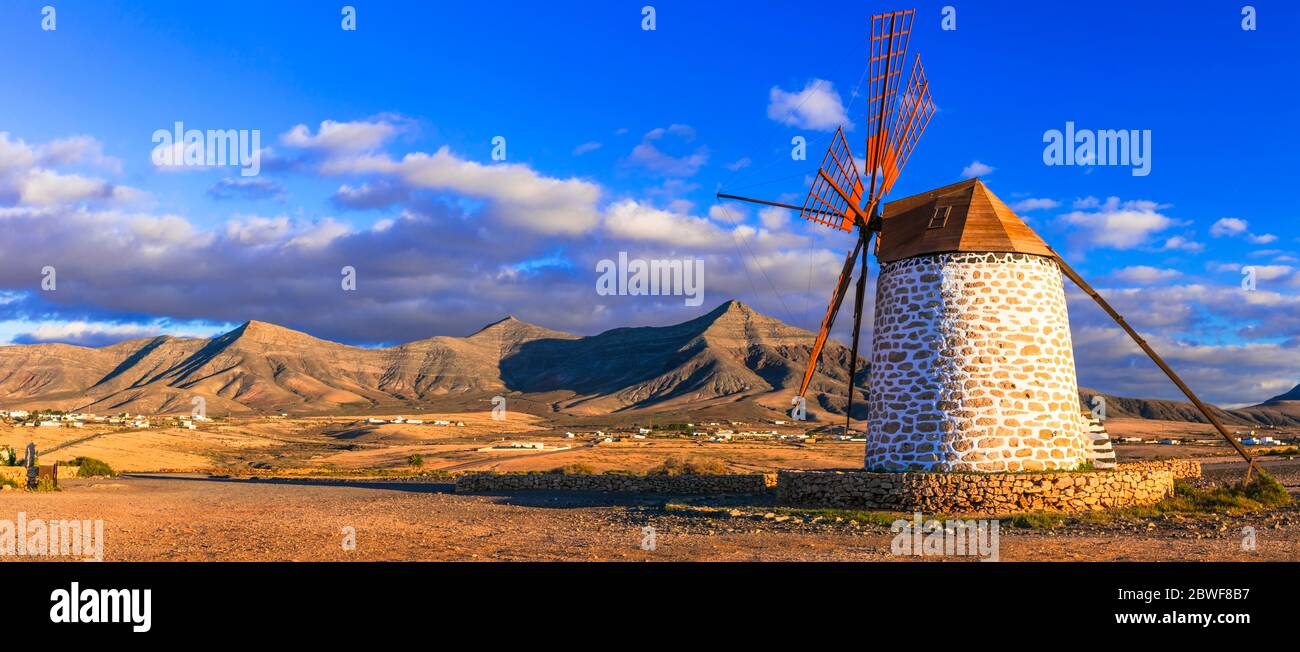 Atemberaubende einsame Schönheit der vulkanischen Insel Fuerteventura. Traditionelle Windmühle bei Sonnenuntergang. Kanarische Inseln, Spanien. Stockfoto