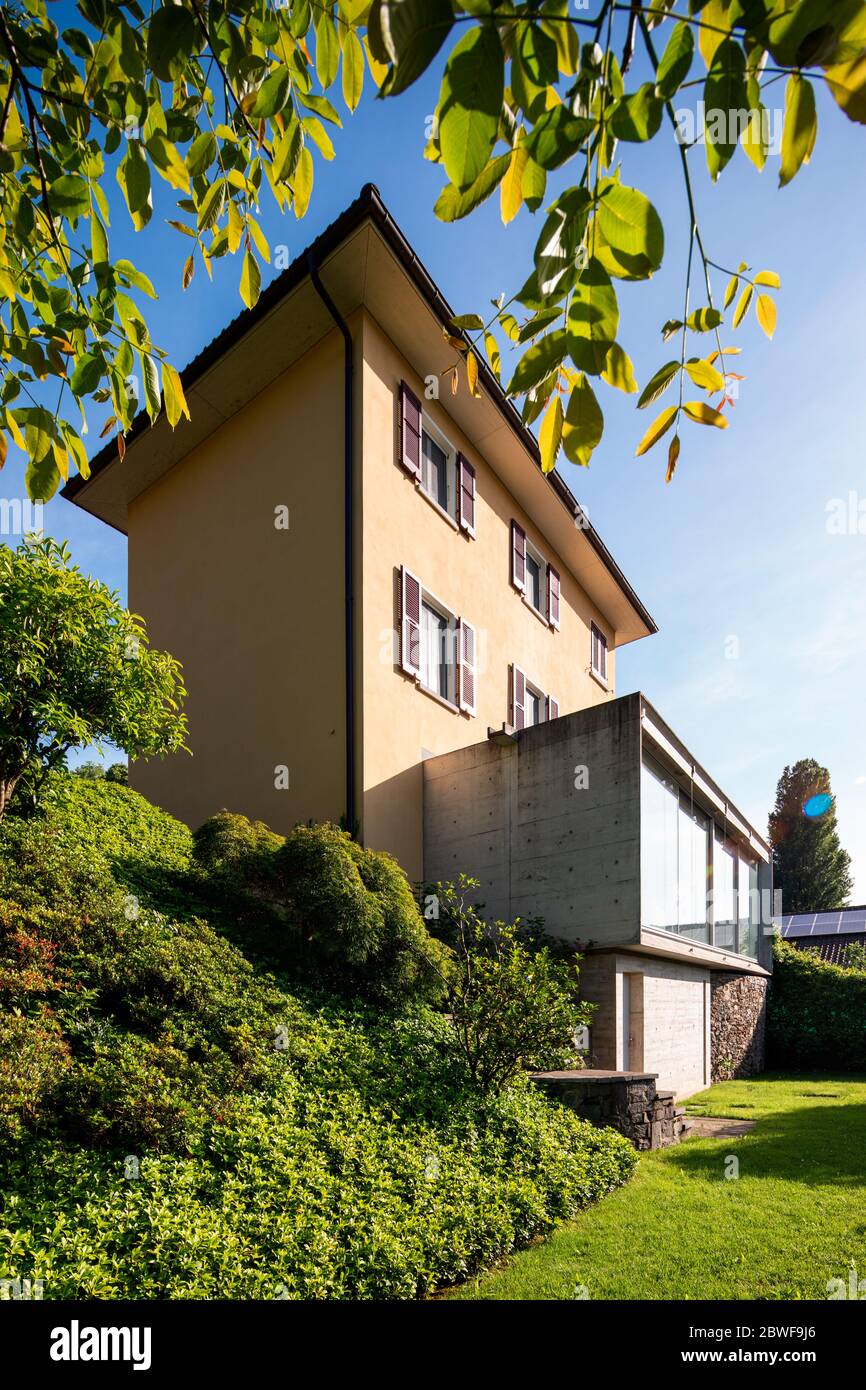 Schönes Haus mitten im Grünen mit einer modernen Stahlbetonverbindung und einem großen Fenster. Stockfoto