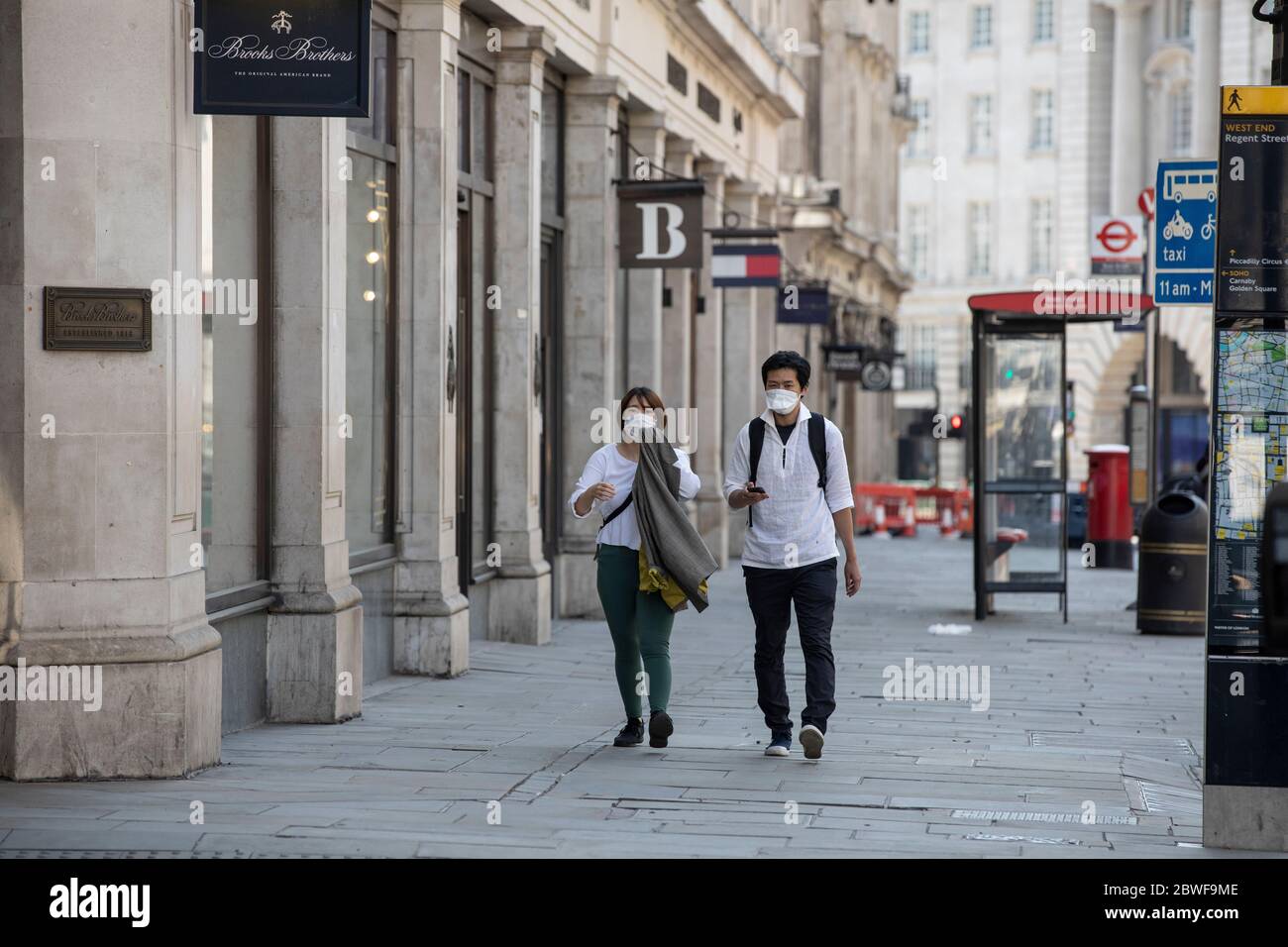 Touristen gehen entlang einer leeren Regent Street im Zentrum von London während der Coronavirus Pandemie Sperrbeschränkungen, wo Geschäfte nicht geöffnet sind, Großbritannien Stockfoto