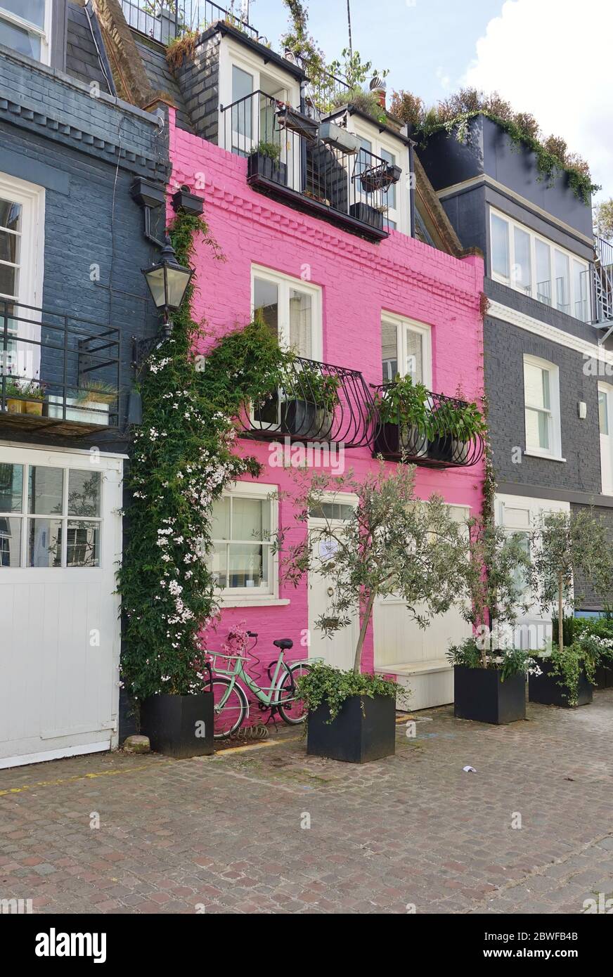 LONDON, UK -16 MAI 2020- EIN Fahrrad vor einem charmanten Haus in rosa gemalt in Notting Hill, London, England. Stockfoto