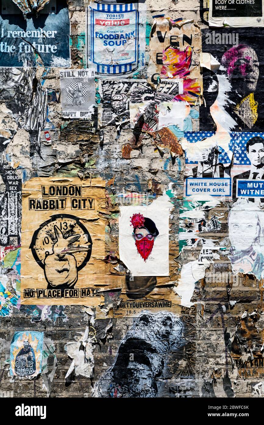 Ziegelwand mit Graffiti, Tags und Plakaten in Fashion Street, Spitalfields, London, Großbritannien Stockfoto
