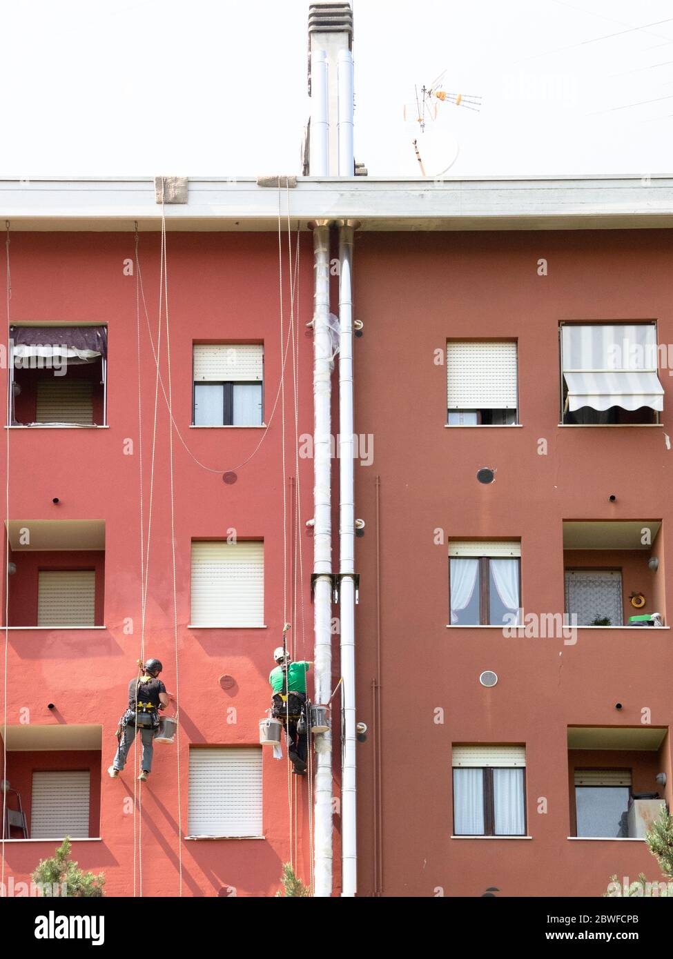 Arbeiten an der Fassade eines Gebäudes mit einem externen Kamin unter Wartung Stockfoto