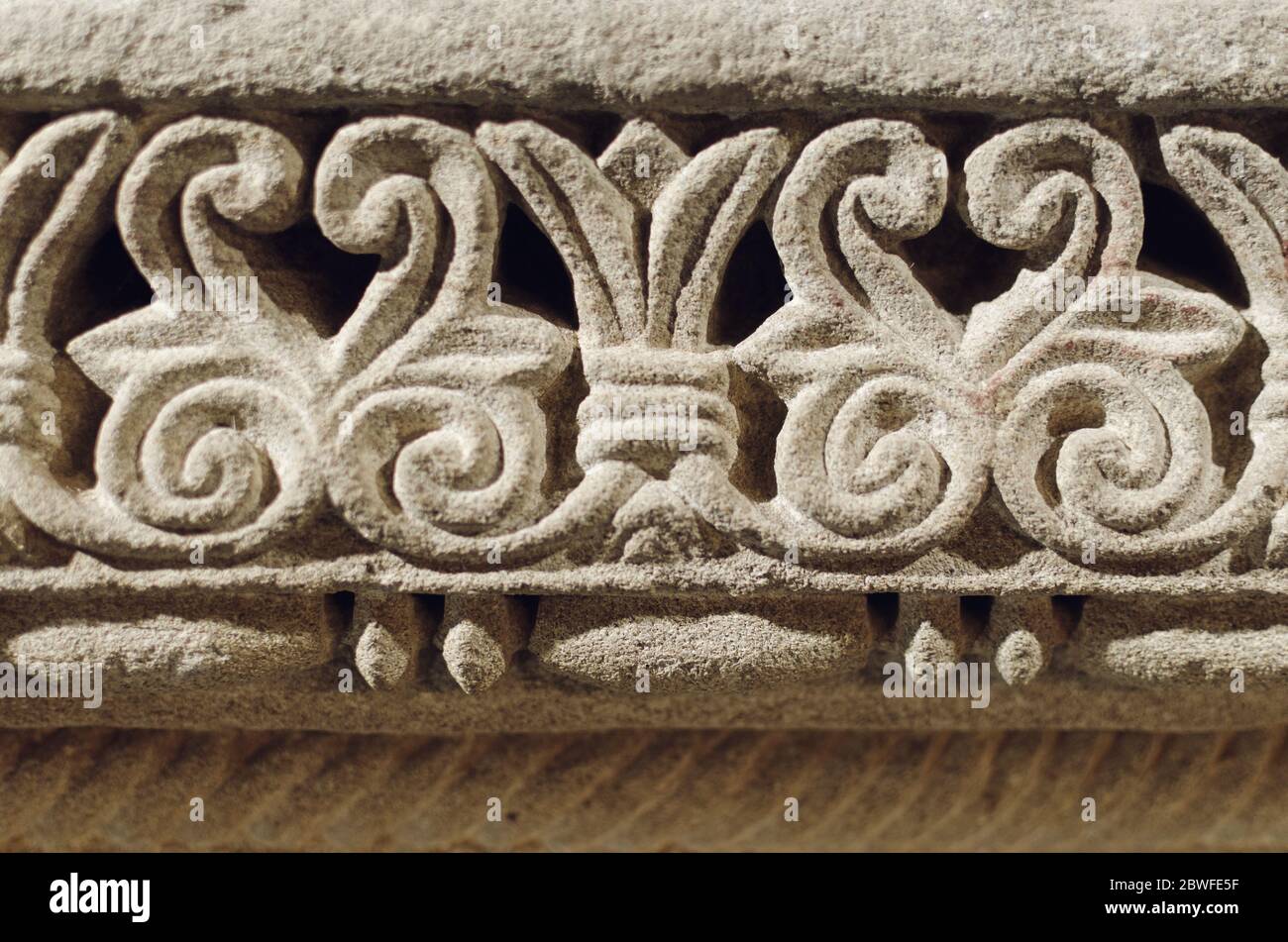Romanische Dekorationen in der Steinmauer einer alten mittelalterlichen Kirche geschnitzt Stockfoto