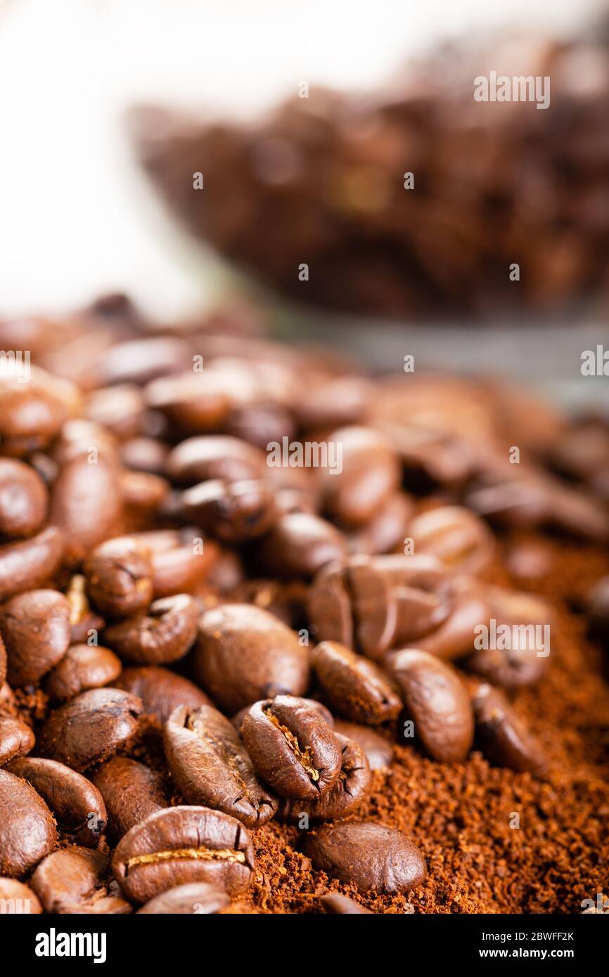 Kaffeebohnen und Kaffeesatz aus nächster Nähe. Hintergrund. Kaffeebohnen in einem Glasgefäß im Hintergrund. Stockfoto