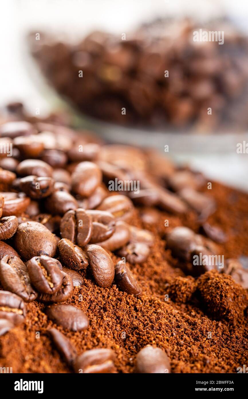 Kaffeebohnen und Kaffeesatz aus nächster Nähe. Hintergrund. Kaffeebohnen in einem Glasgefäß im Hintergrund. Stockfoto