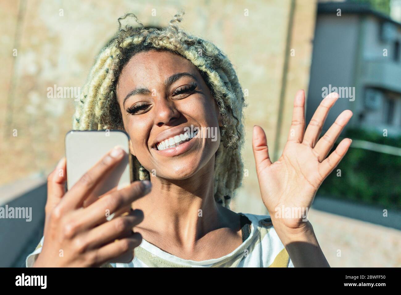 Youd african Frau mit blonden Dreadlocks tun Videoanruf mit Smartphone - trendy Person, die Spaß mit Technologie-Trends - Tech, Lifestyle Stockfoto