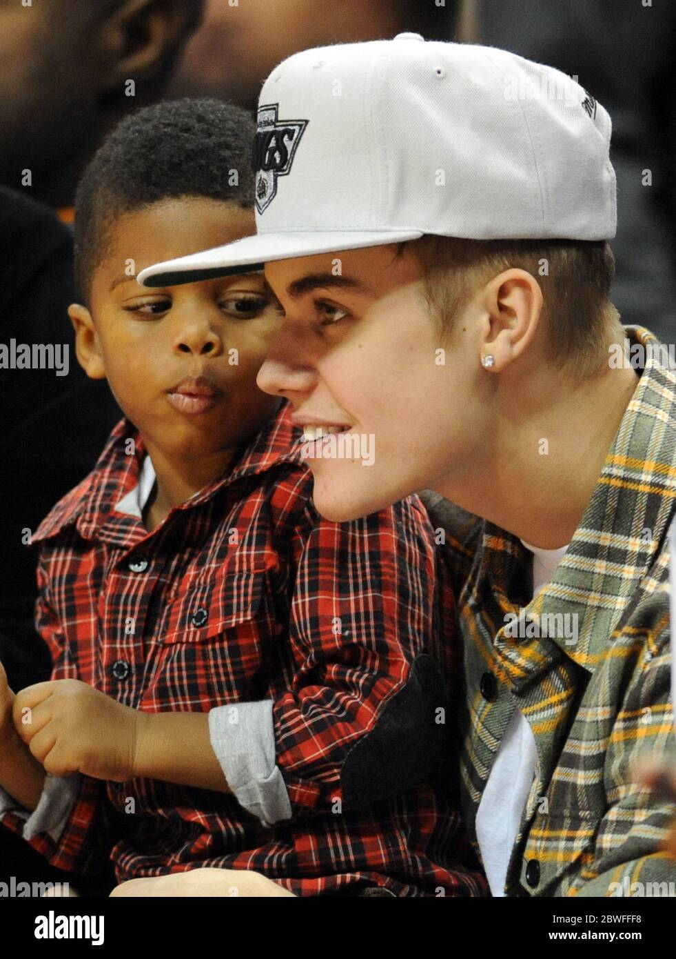 Justin Bieber mit Chris Paul II, dem Sohn des LA Clippers-Spielers Chris Paul, während sie beide Los Angeles Clippers beim NBA-Spiel im Staples Center in Los Angeles, Kalifornien, beobachten. 27 Dezember 2012 Stockfoto