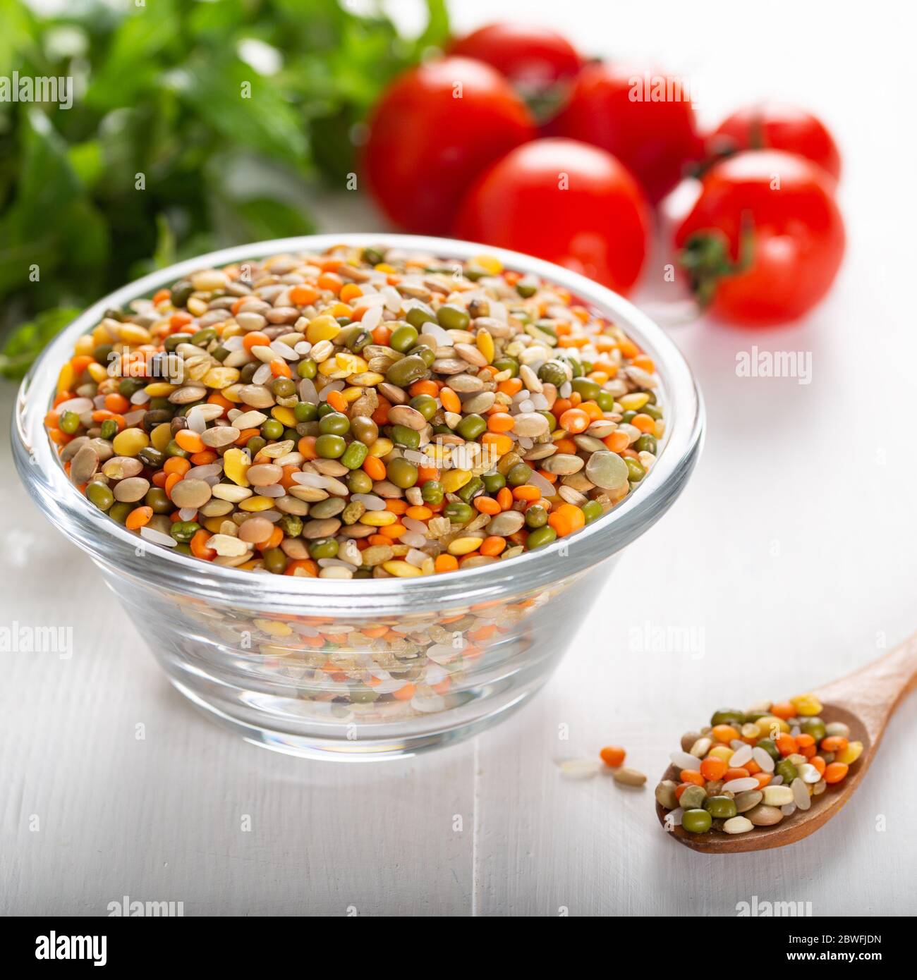 Bunte verschiedene Bohnen oder Linsen und Vollkornsamen oder Getreide in Schüssel mit frischem Gemüse. Stockfoto