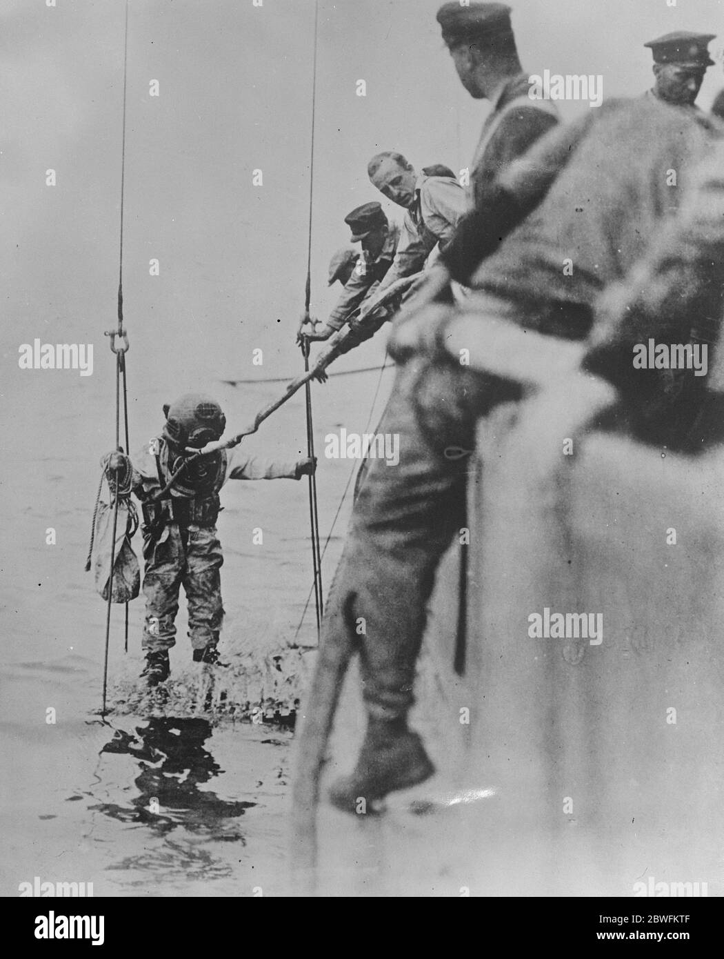 Taucheinsatz auf versunkenem U-Boot Dieses offizielle Foto der US Navy zeigt einen Taucher, der zum U-Boot S51 absteigt, das von der "Stadt Rom" vor Block Island versenkt wurde. 14. November 1925 Stockfoto