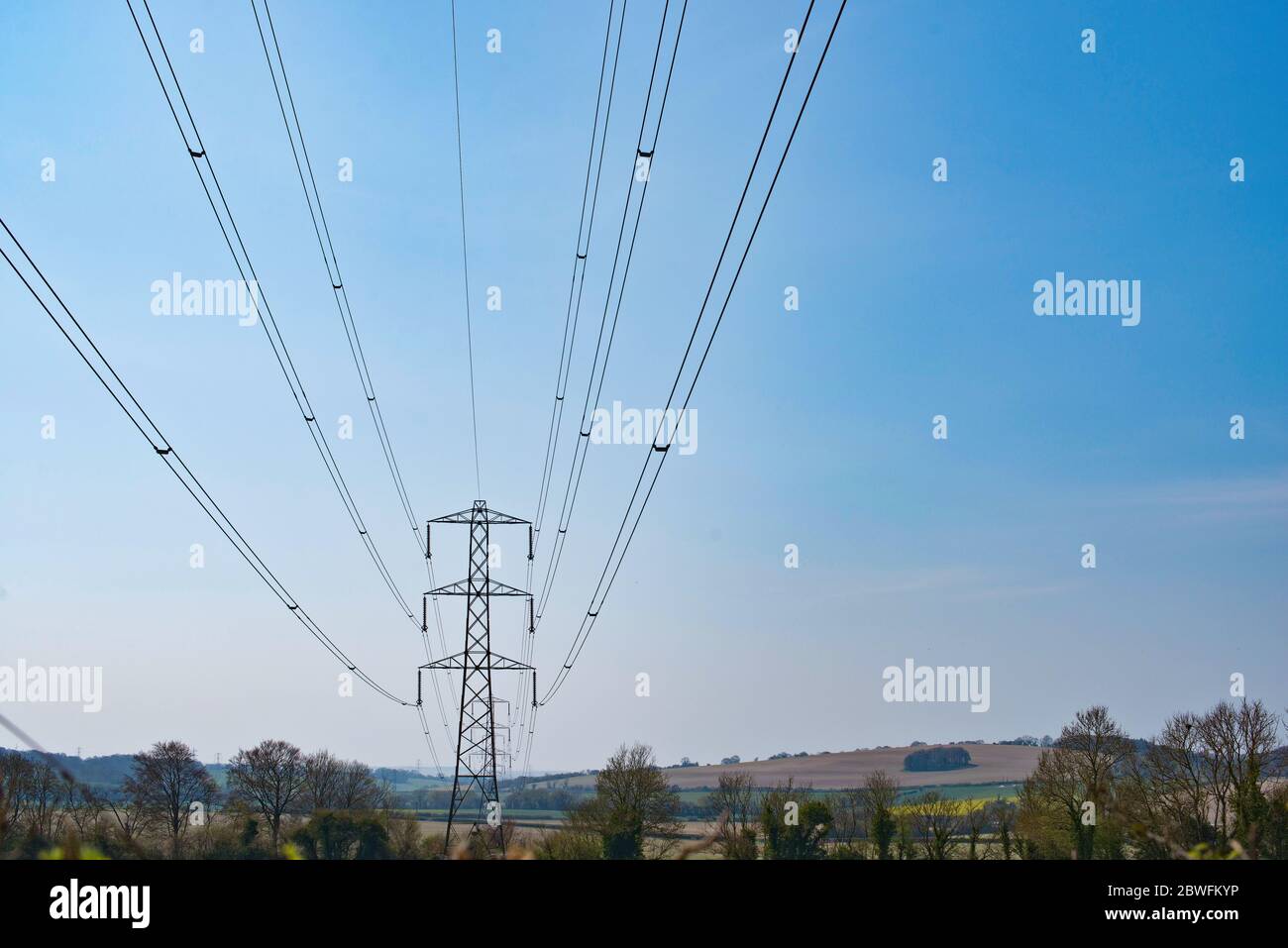 Stromlinien in der Ferne in Richtung Pylon gegen einen blauen Himmel. Stockfoto