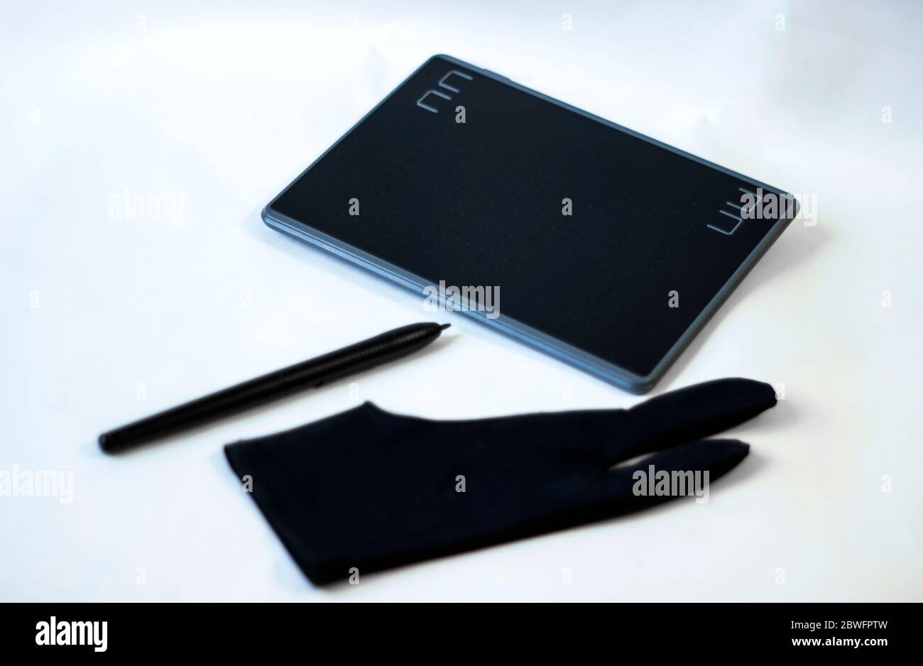 Grafiktablett mit Stift für Illustratoren, Maler und Designer auf weißem Hintergrund. Grafiktablett, Stift und schwarzer Handschuh für Illustratoren und Design Stockfoto