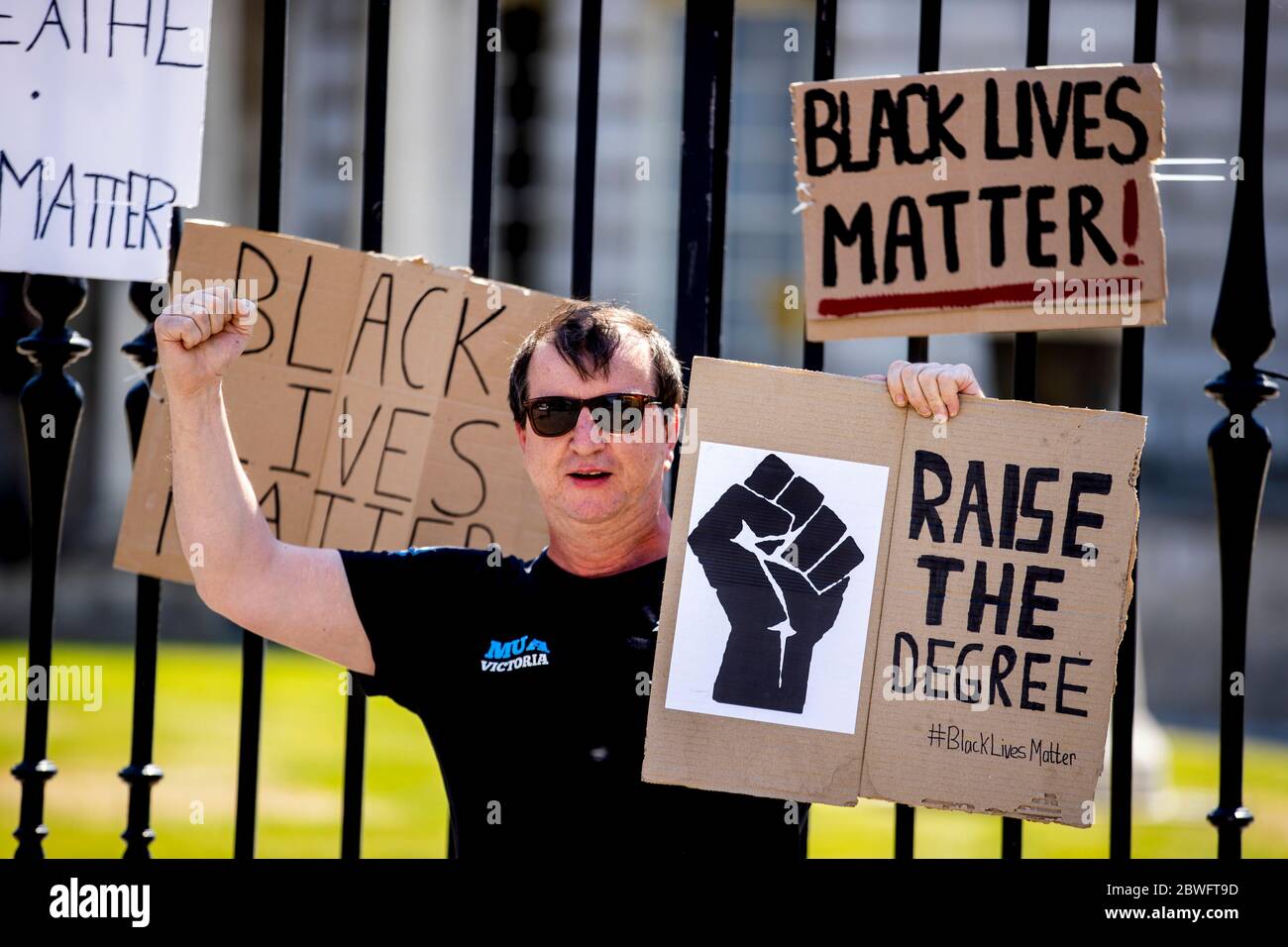 Sean McKernan hält ein Zeichen, ÒRaise den Abschluss. #BlackLiveMatter,Ó bei einer Protestkundgebung vor dem Belfast City Hall in Belfast, nach dem Tod von George Floyd in Minneapolis, USA. Stockfoto