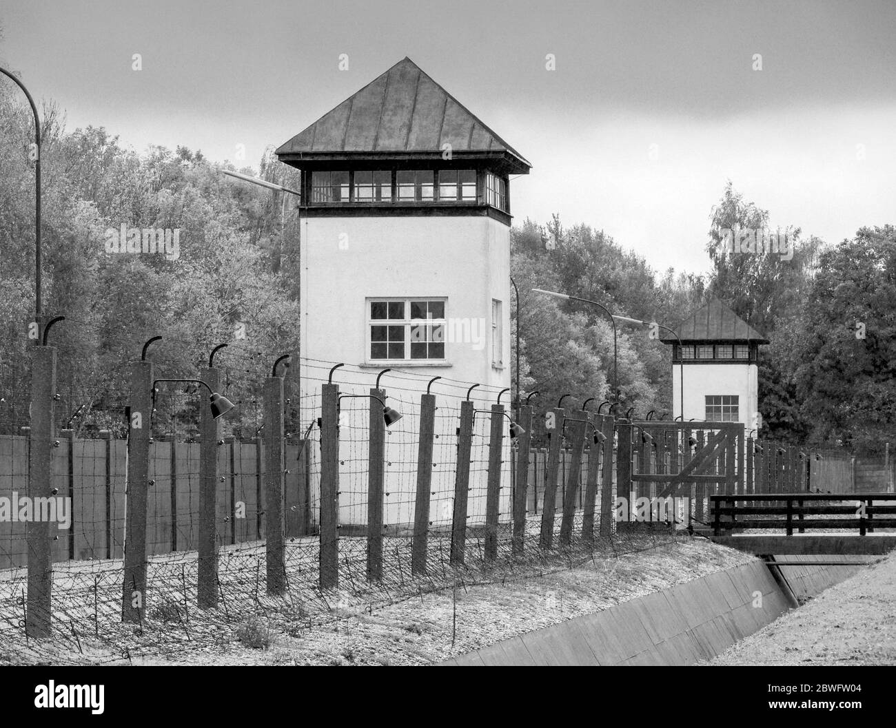 Elektrifizierte Stacheldrahtzäune und ein Wachturm im KZ Dachau. Es war das erste Nazi-Konzentrationslager und war ein Prototyp f Stockfoto