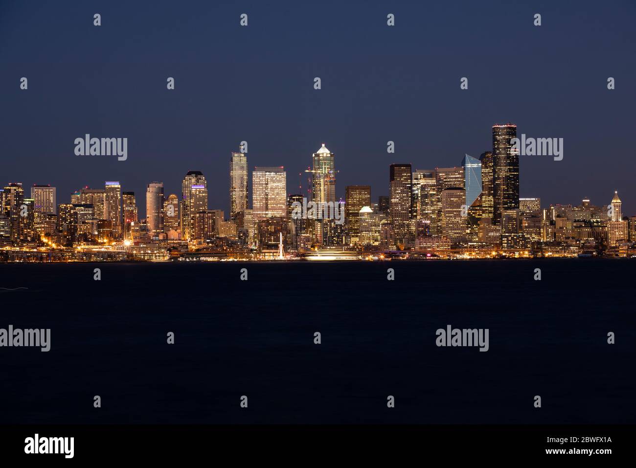 Beleuchtete Skyline am Wasser bei Nacht, Seattle, Washington, USA Stockfoto
