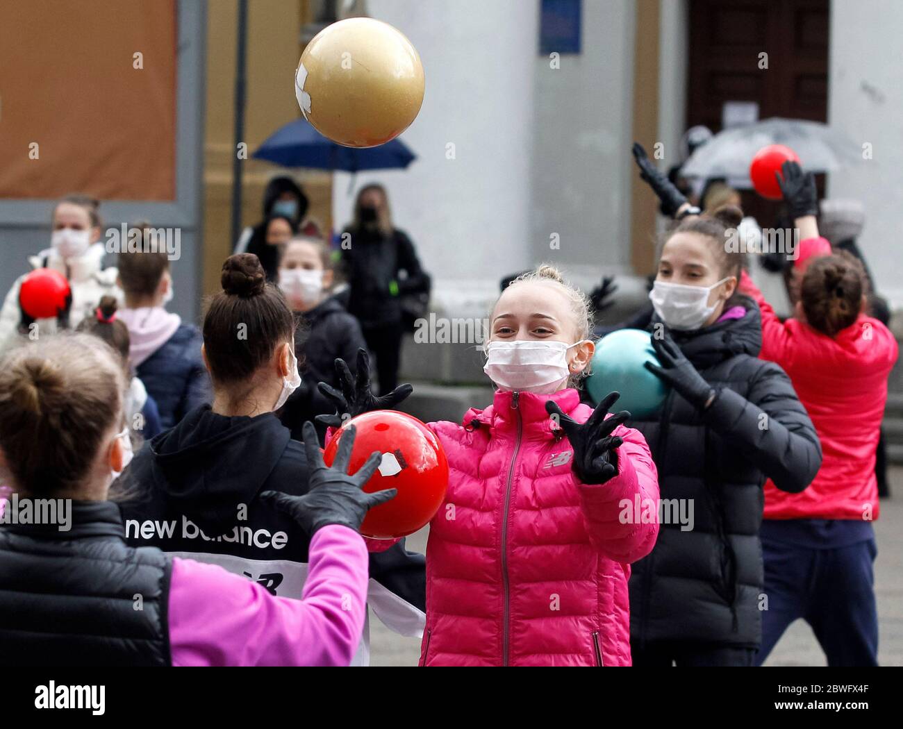 Kiew, Ukraine. Juni 2020. Junge Turner, die Schutzmasken und Handschuhe tragen, um die Krankheit COVID-19 zu verhindern, führen am 1. Juni 2020 im Rahmen eines Open-Air-Trainings in der Innenstadt von Kiew, Ukraine, durch. Die Athleten der Irina Deryugina Gymnastikschule hielten Open-Air-Trainingseinheiten ab, während ihrer Aktion "Save Deriugina School" protestierte gegen die Schließung ihres Trainingsraums, wie lokale Medien berichteten. Kredit: Serg Glovny/ZUMA Wire/Alamy Live News Stockfoto