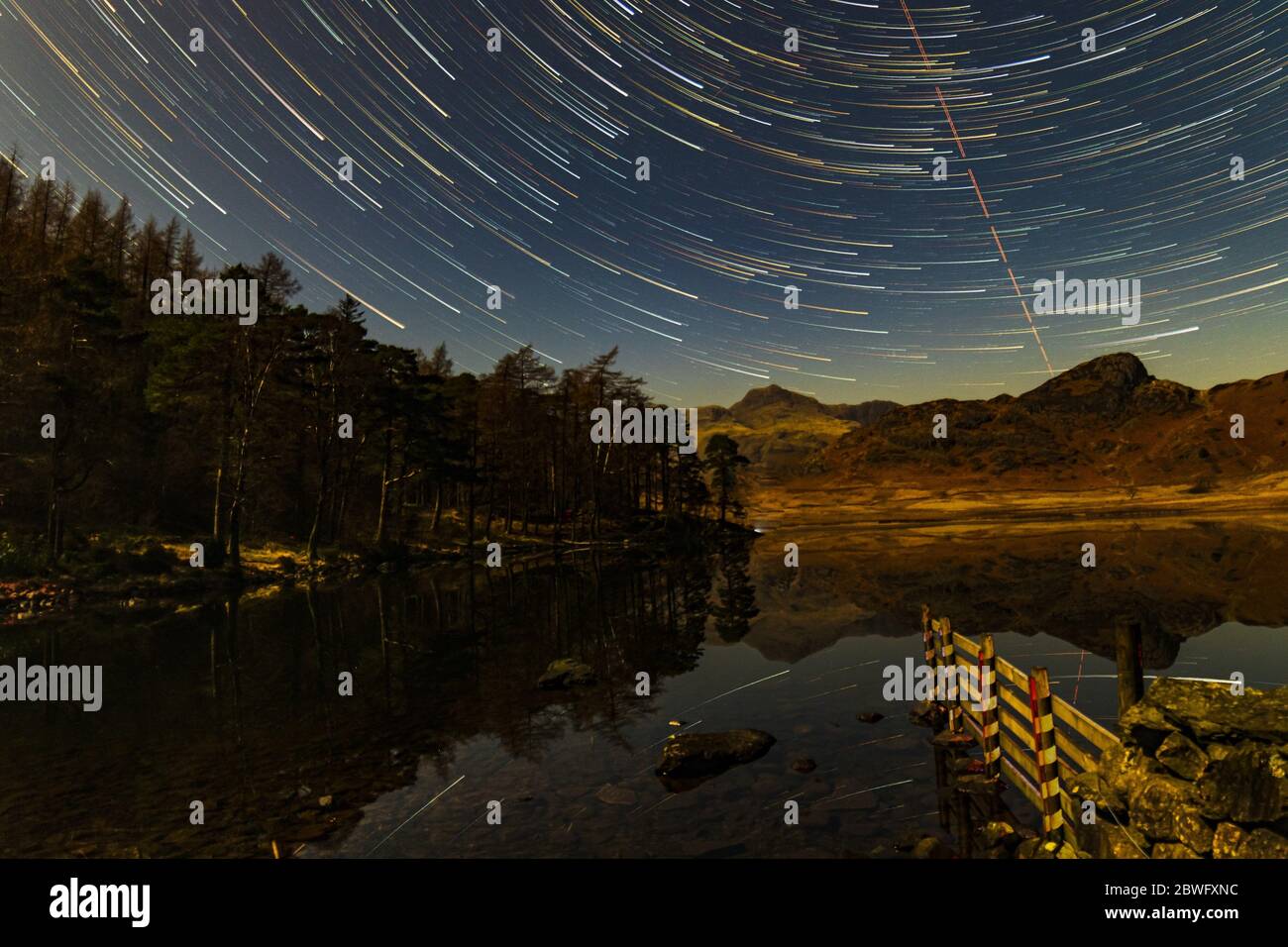 Sterne Trails über Blea Tarn in einer mondhellen Nacht Stockfoto