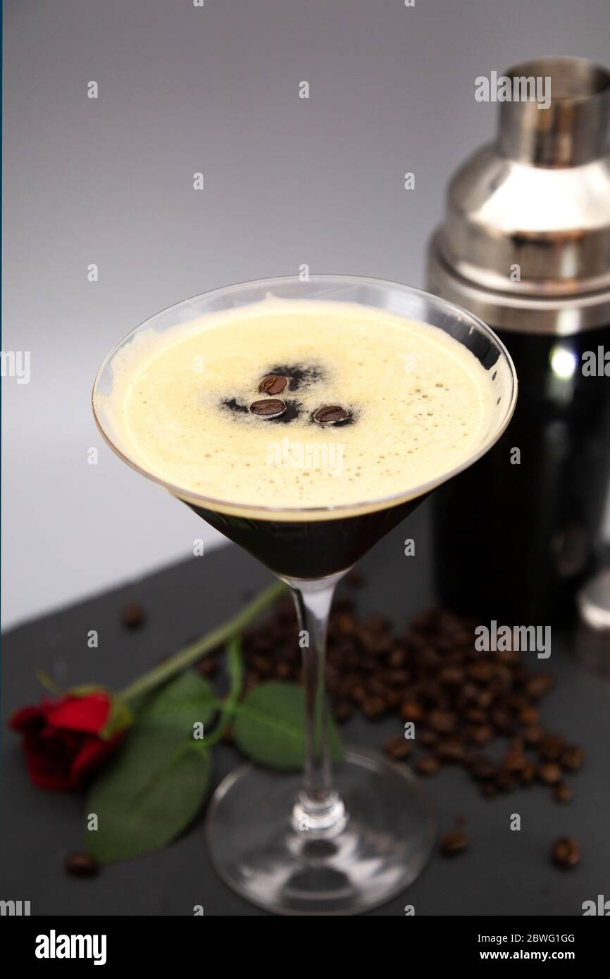 Ein Espresso Martini in einem martiniglas serviert und mit gerösteten Kaffeebohnen garniert. Das Glas wird mit frisch gerösteten Kaffeebohnen gesehen. Stockfoto