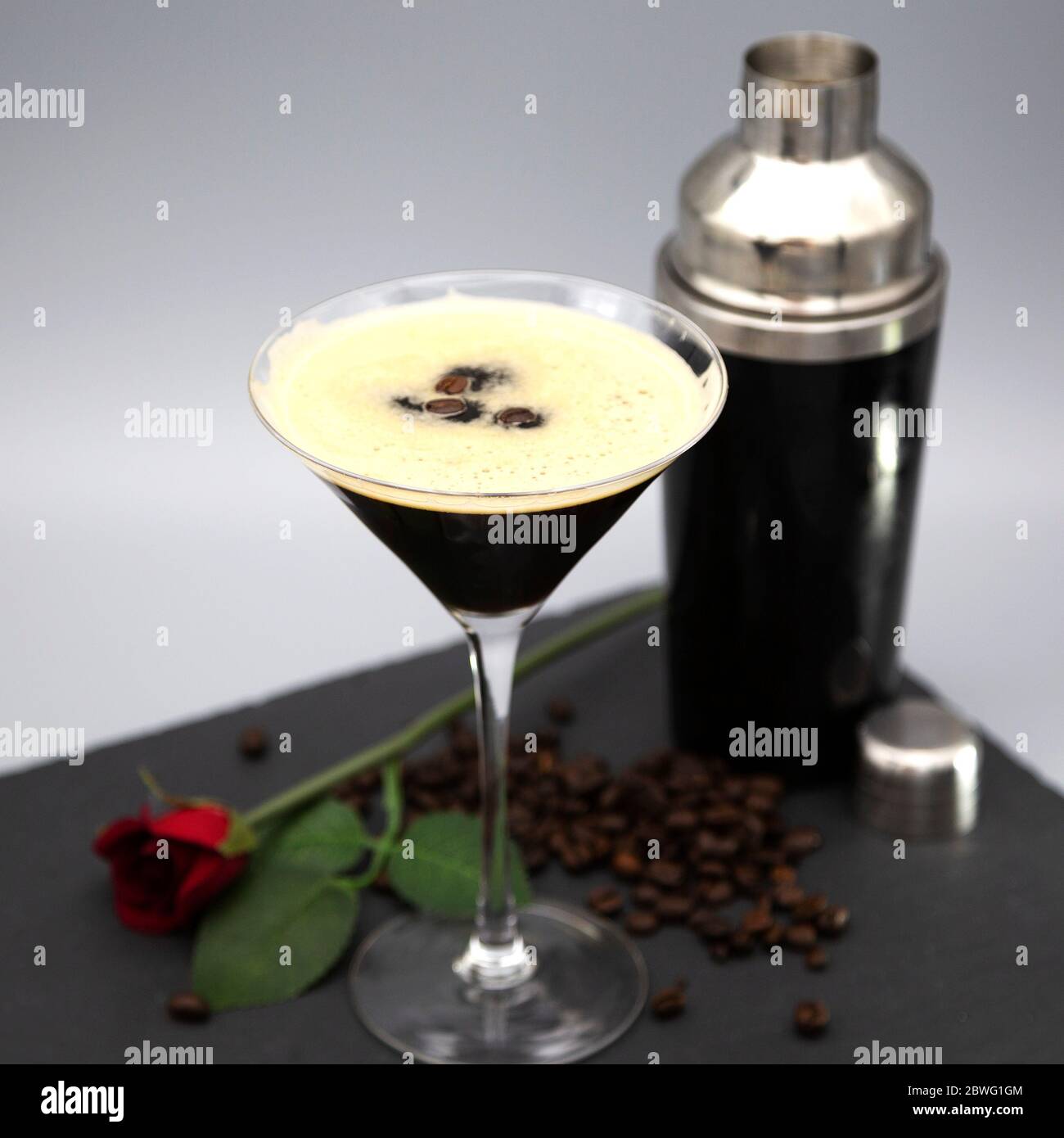Ein Espresso Martini in einem martiniglas serviert und mit gerösteten Kaffeebohnen garniert. Das Glas wird mit frisch gerösteten Kaffeebohnen gesehen. Stockfoto