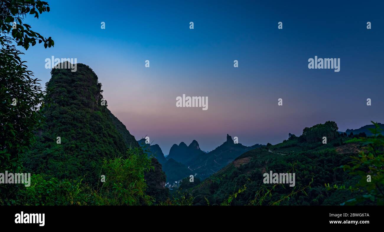 Xianggong Hügel Blick auf schöne grüne, üppige und dichte Karstgebirgslandschaft in der Dämmerung, Yangshuo, Guangxi Provinz, China Stockfoto