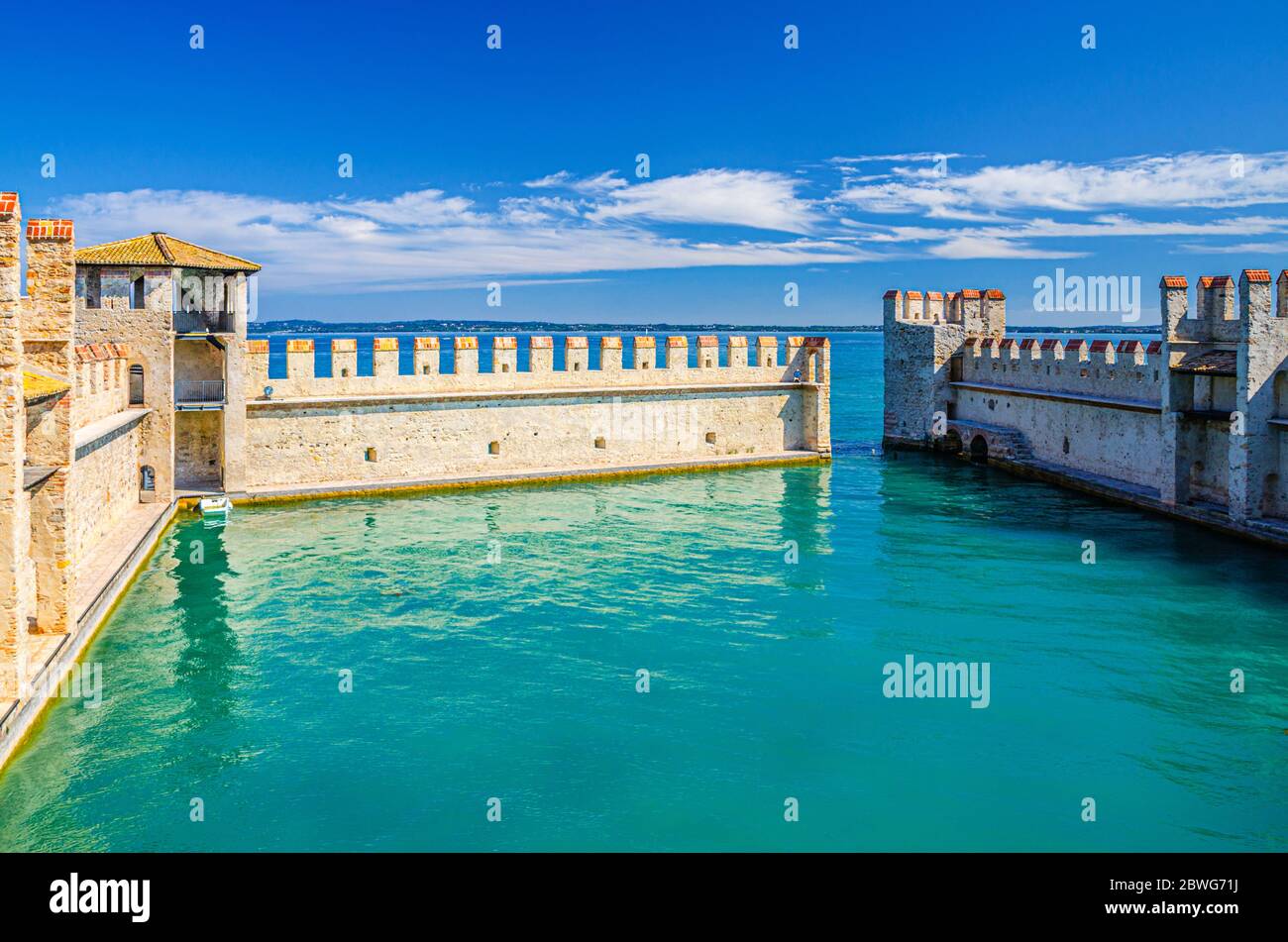 Sirmione, Italien, 11. September 2019: Kleiner befestigter Hafen mit türkisfarbenem Wasser, Scaligero Burg Castello Festung, Stadt am Gardasee, mittelalterliche Burg mit Steintürmen und Backsteinmauern, Lombardei Stockfoto