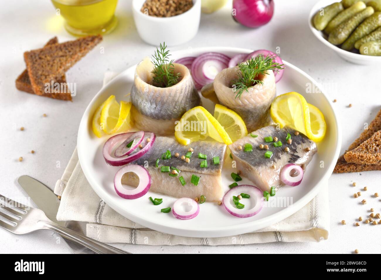 Gesalzener Hering mit Gewürzen und Zwiebeln auf dem Teller. Russische Küche, Nahaufnahme Stockfoto