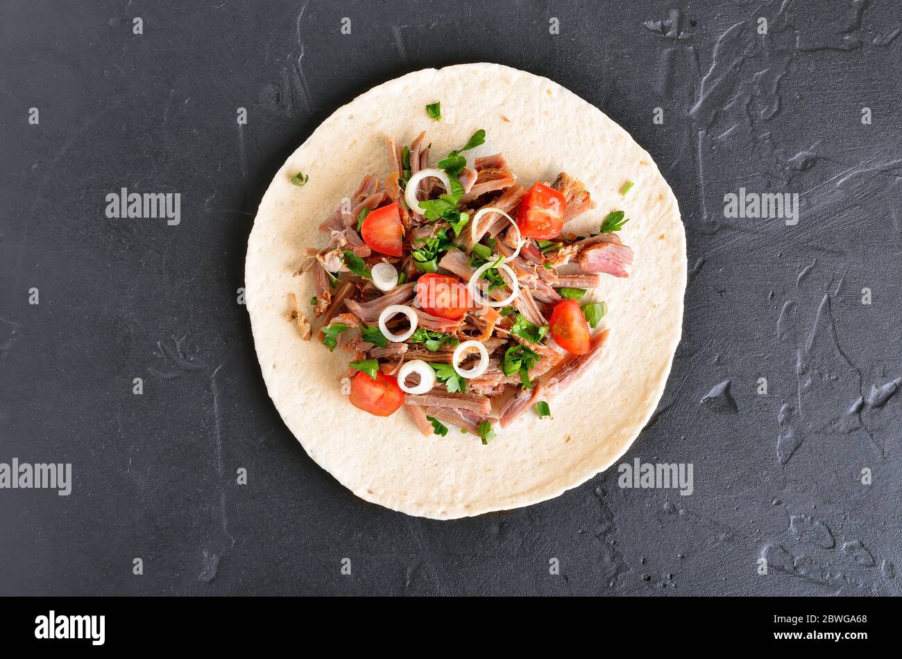 Zog Schweinefleisch soft Tacos auf schwarzem Stein. Ansicht von oben, flach Stockfoto
