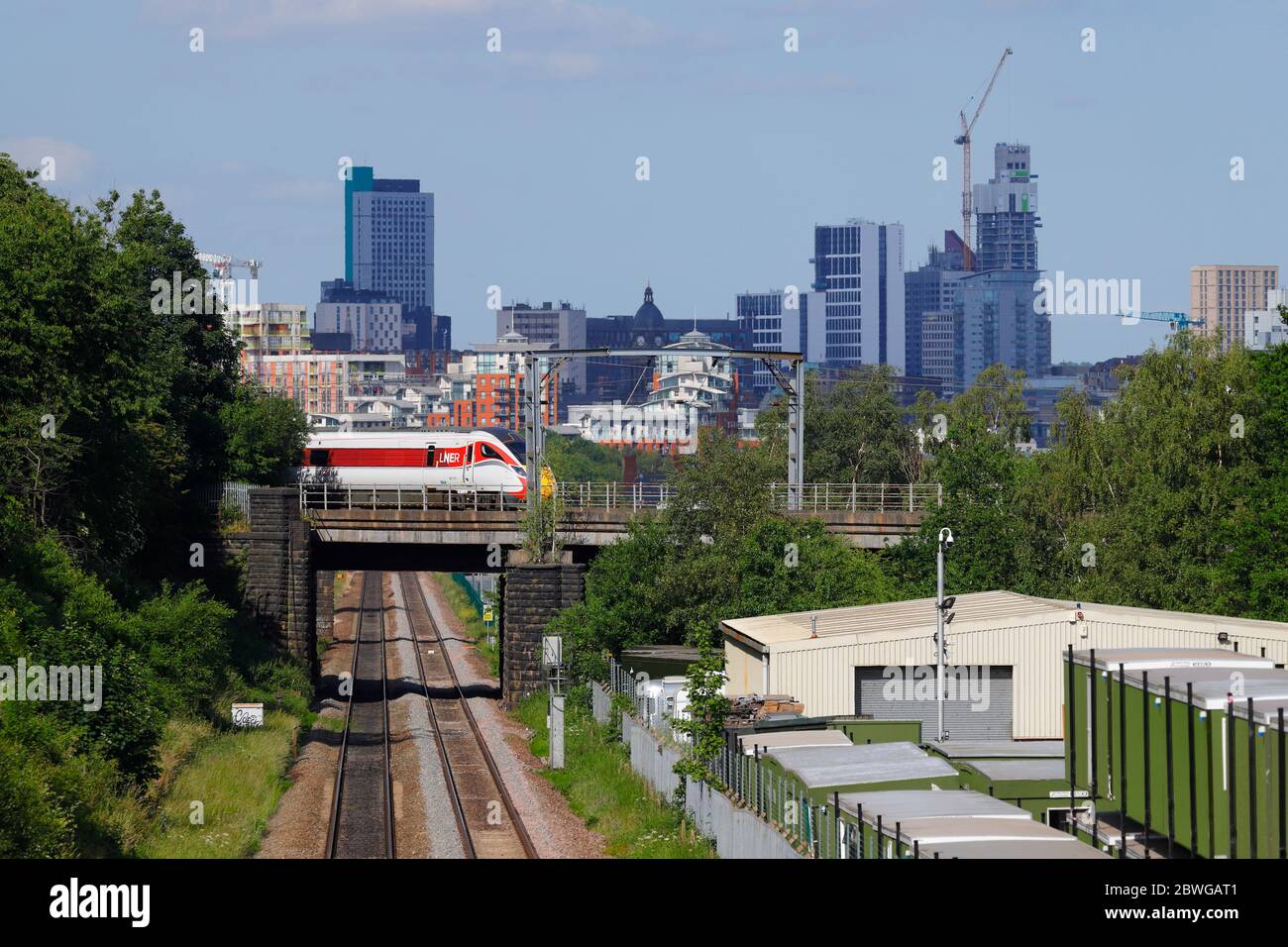 Ein von LNER betriebener Zug der Baureihe 800 Azum fährt vor der Skyline von Leeds in die Innenstadt von Leeds Stockfoto