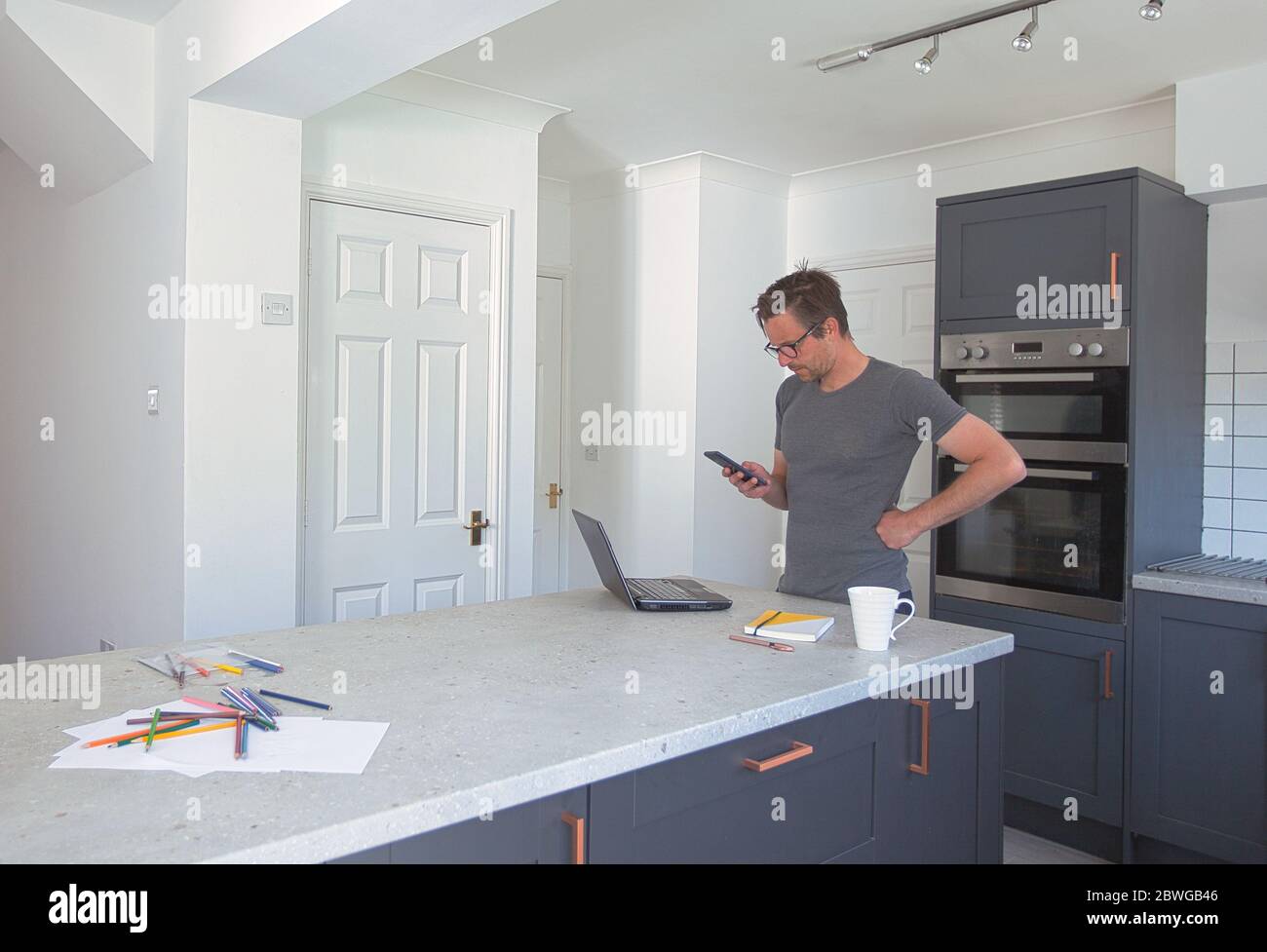 Mann arbeitet von zu Hause aus in der Küche Stockfoto