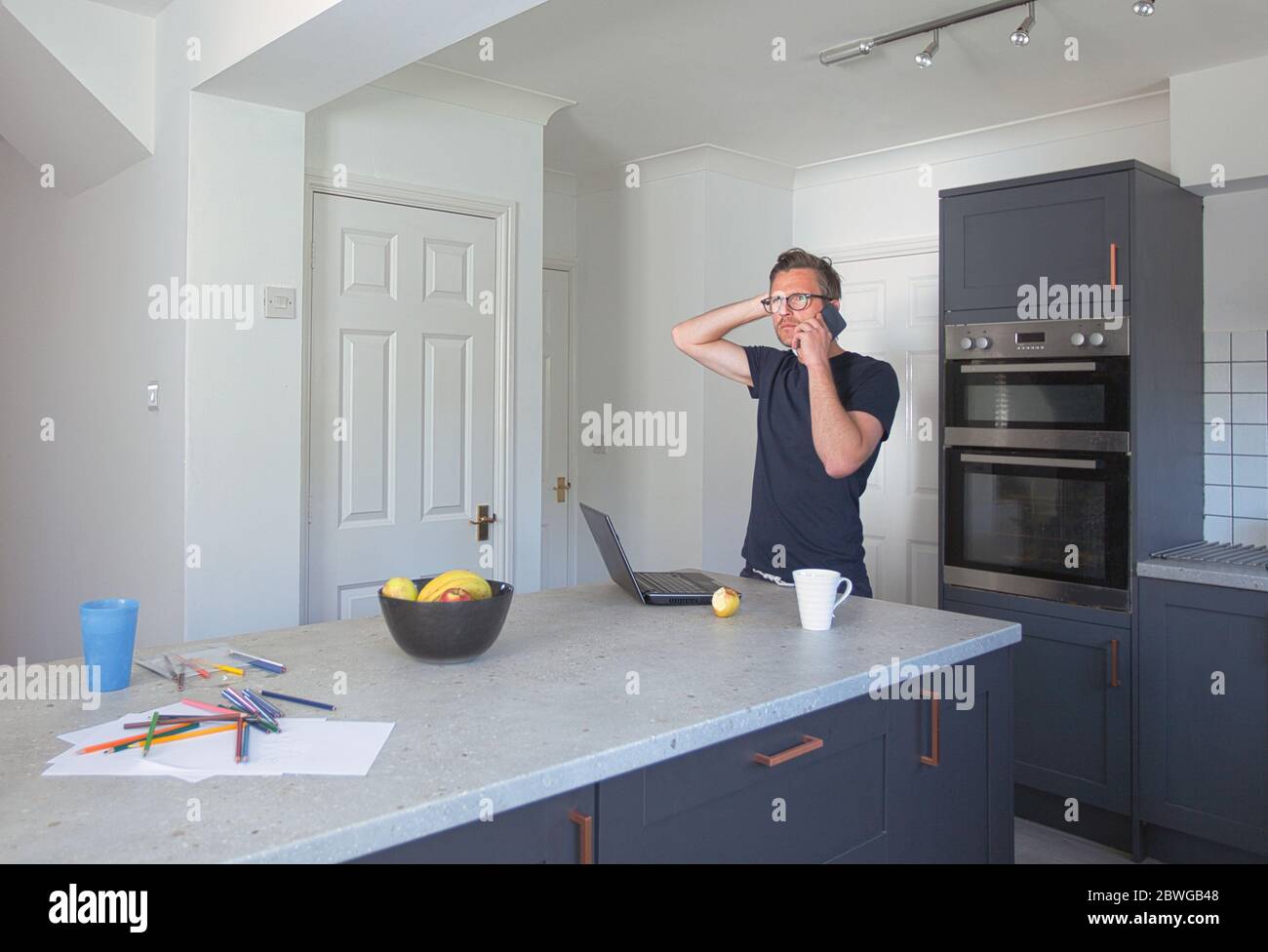 Mann arbeitet von zu Hause aus in der Küche Stockfoto