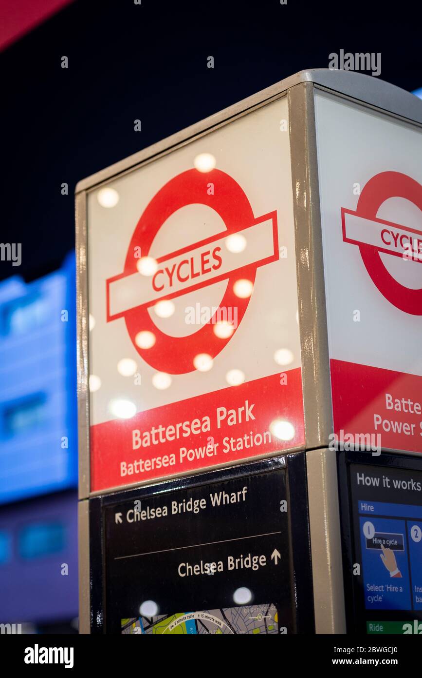 Schild für Fahrradverleih-Dockingstation für Battersea Park und Battersea Power Station, beleuchtet bei Nacht im Zentrum von London, Großbritannien Stockfoto