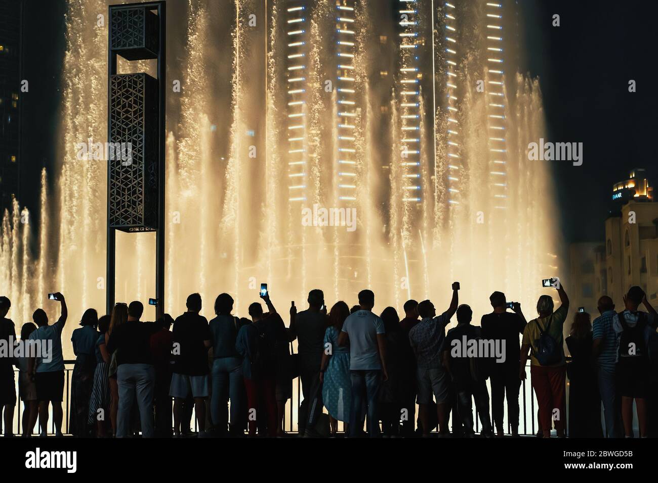 DUBAI, VAE - Februar 2020 : Nachtansicht von Dubai Dancing Fountains Downtown und viele Menschen, die sich die Wassershow ansehen. Stockfoto