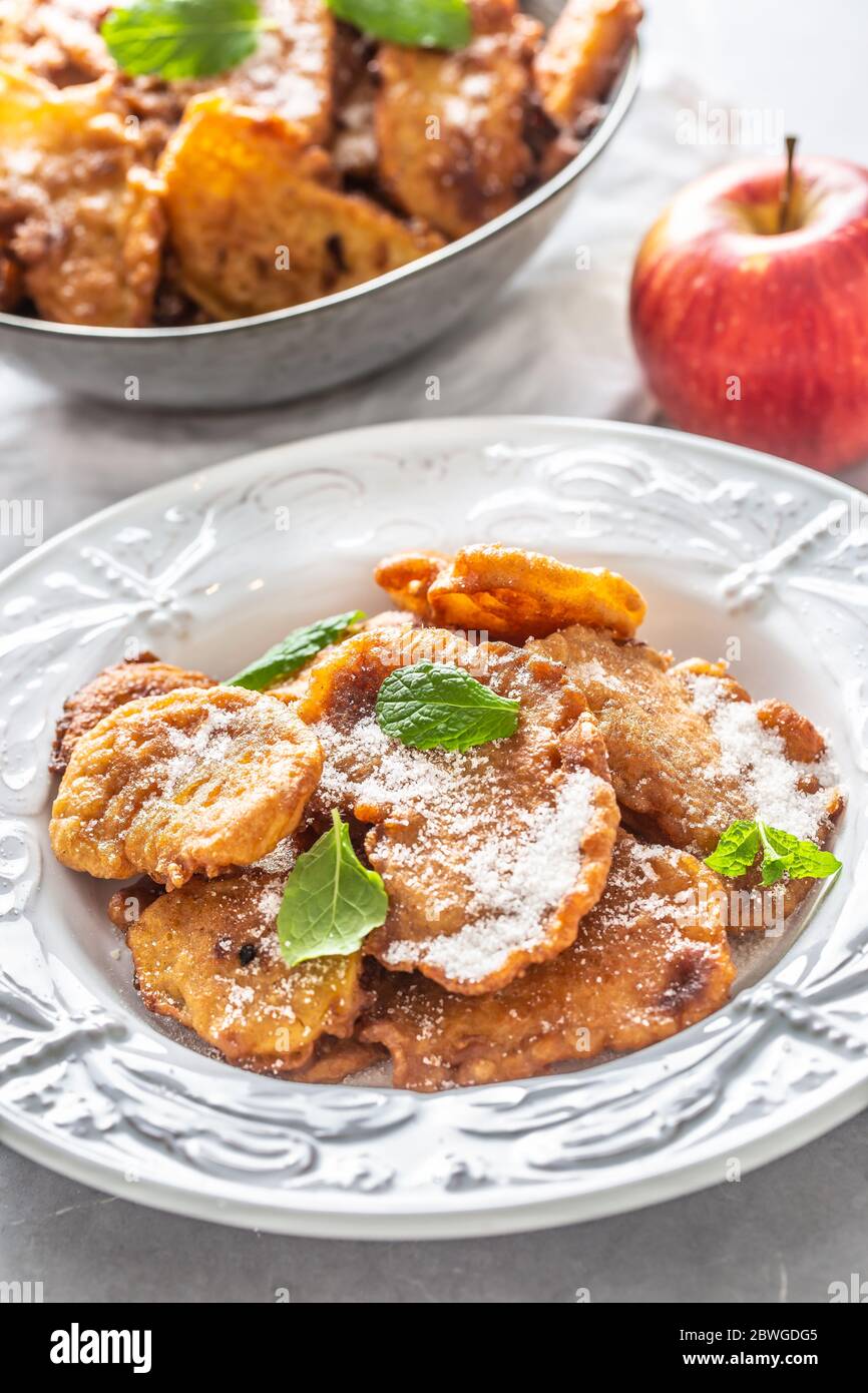 Fein gebratene Apfelpfannkuchen, bestreut mit Vanillezucker und Zimt, gekrönt mit Minzblättern Stockfoto