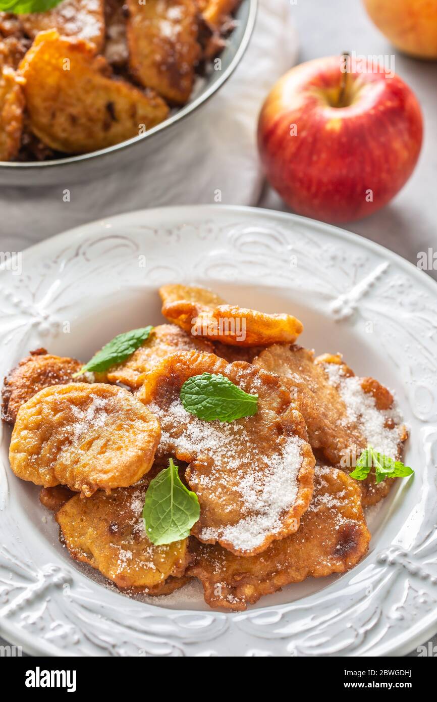 Fein gebratene Apfelpfannkuchen, bestreut mit Vanillezucker und Zimt, gekrönt mit Minzblättern Stockfoto