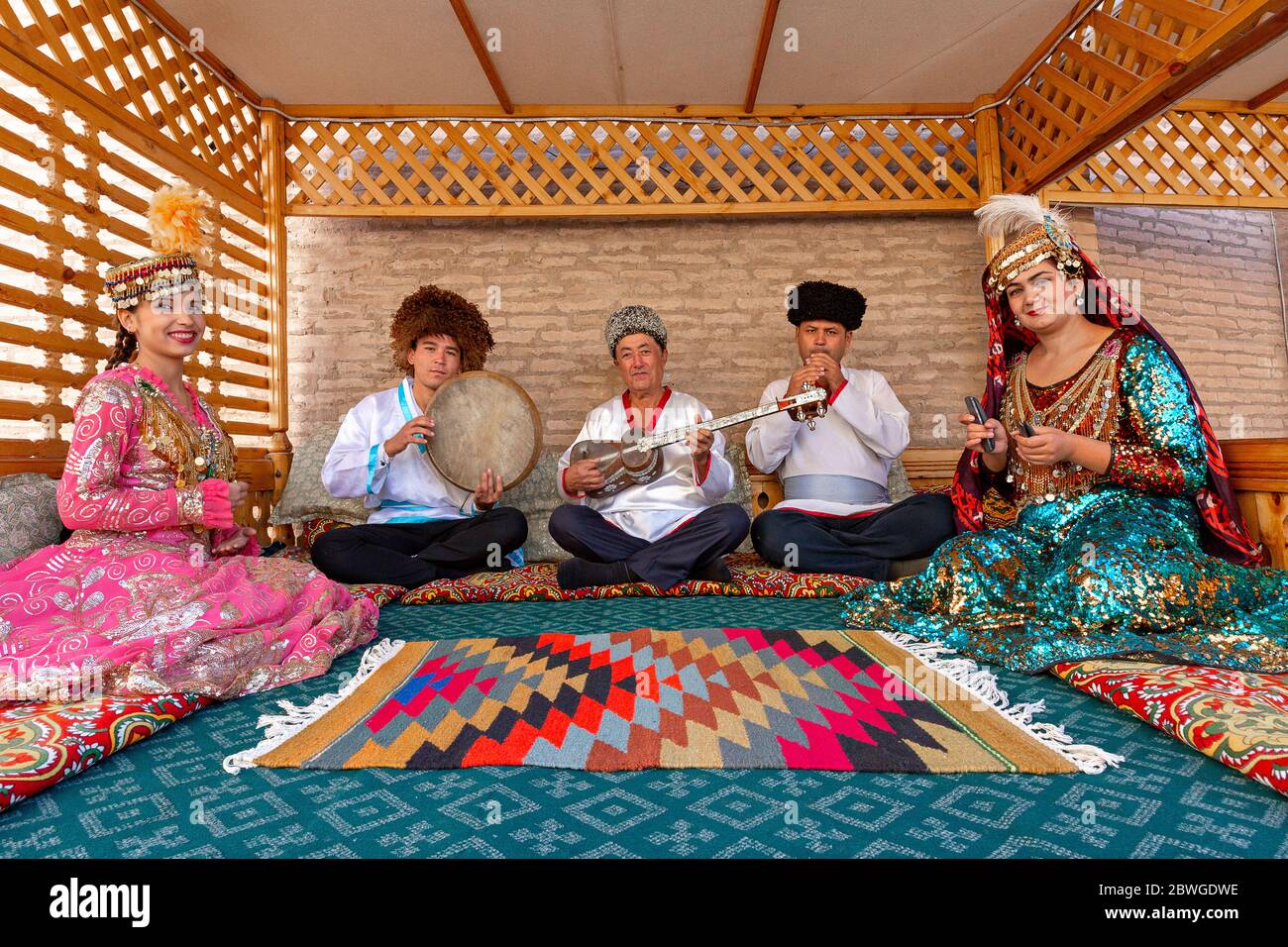 Usbekische Musiker in traditioneller Kleidung, die Musikinstrumente spielen und lokale Lieder singen, in Chiwa, Usbekistan Stockfoto