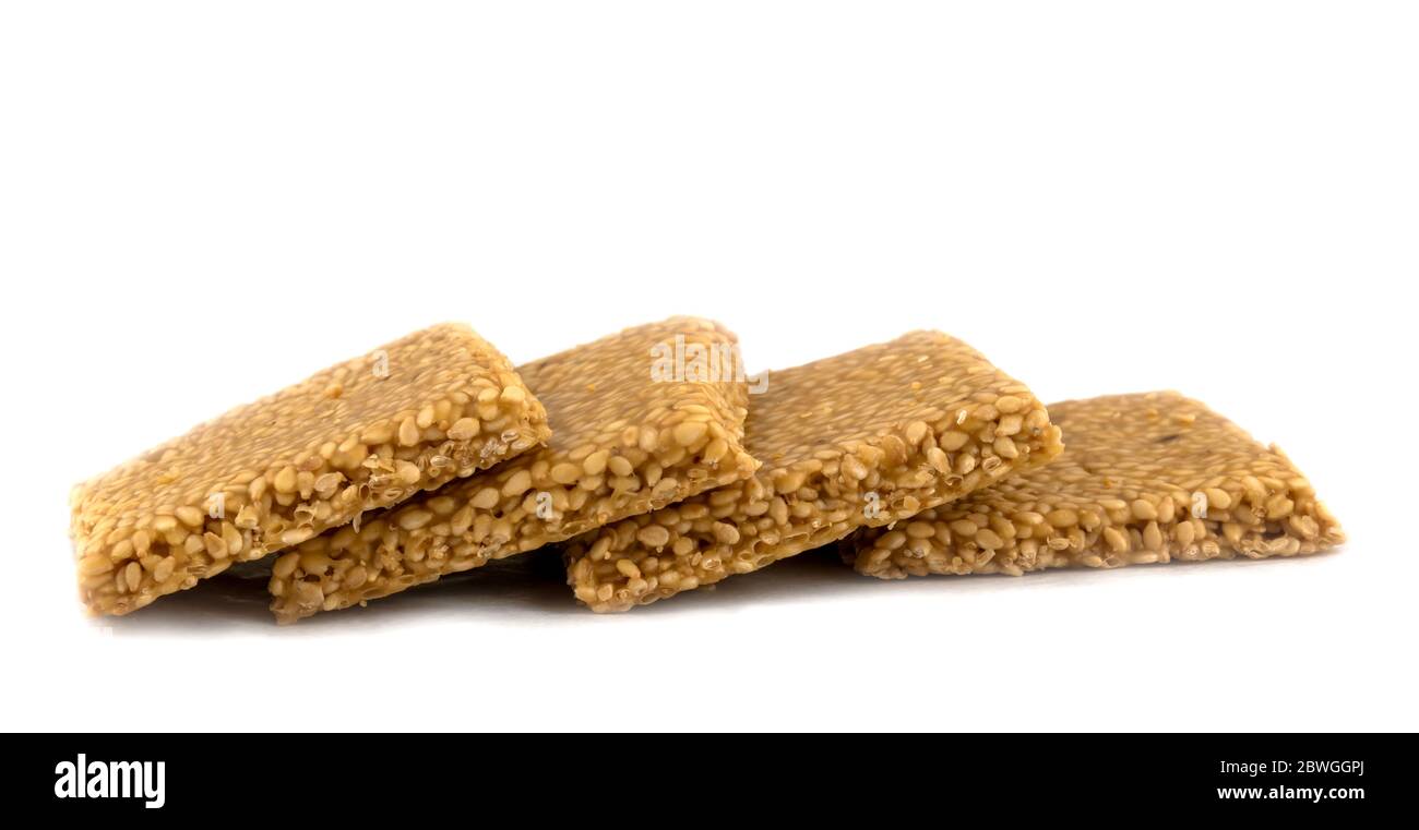 Til chikki auf weißem Hintergrund ist ein indisches süßes Gericht mit Jaggery und Sesam Stockfoto
