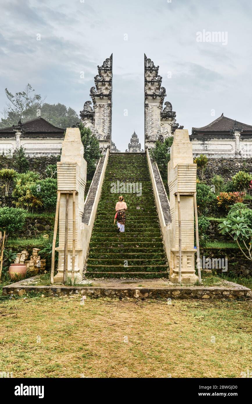 Frau auf der Treppe zum Eingang des Pura Lempuyang Tempels auf Bali, Indonesien Stockfoto