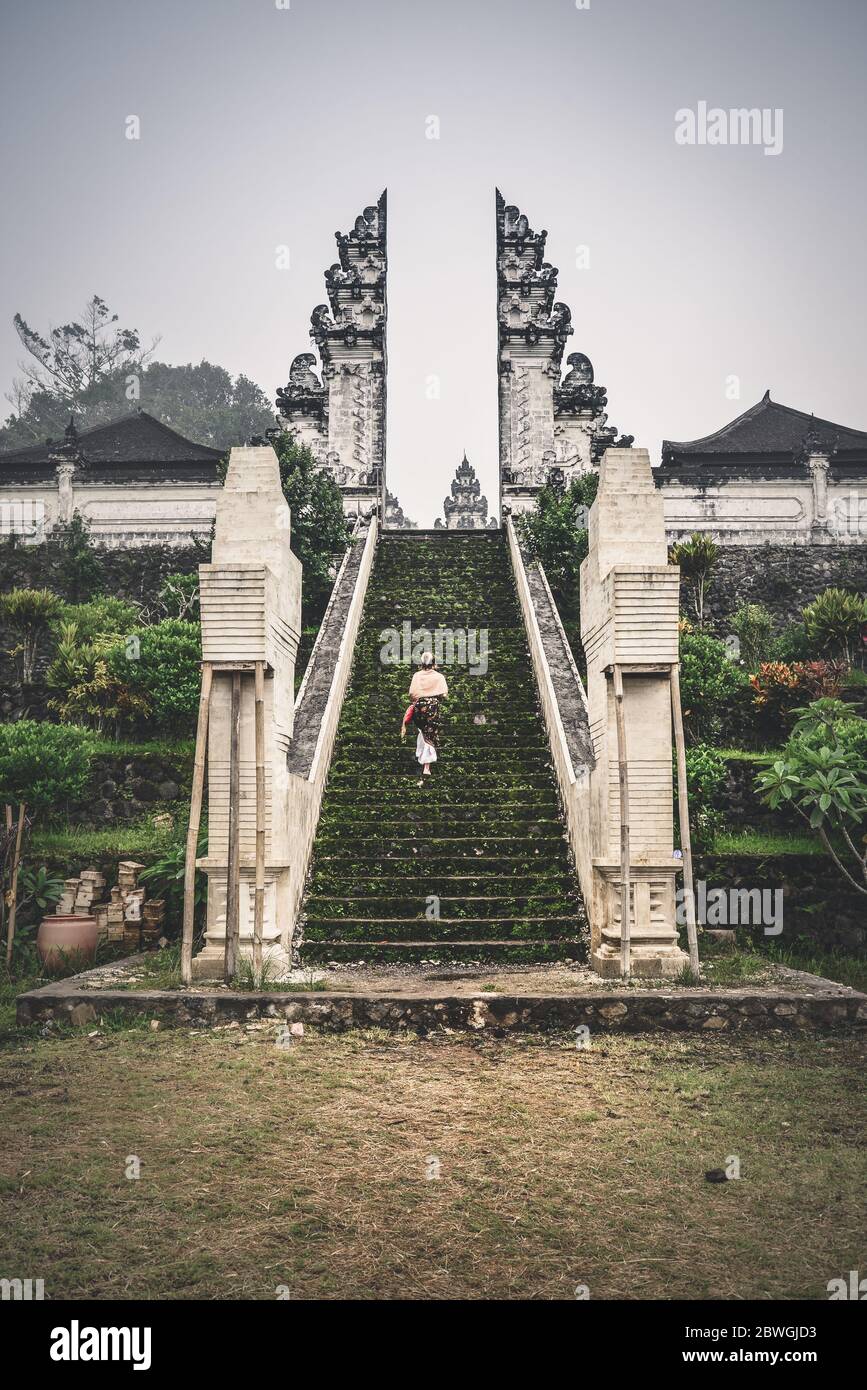 Frau auf der Treppe zum Eingang des Pura Lempuyang Tempels auf Bali, Indonesien Stockfoto