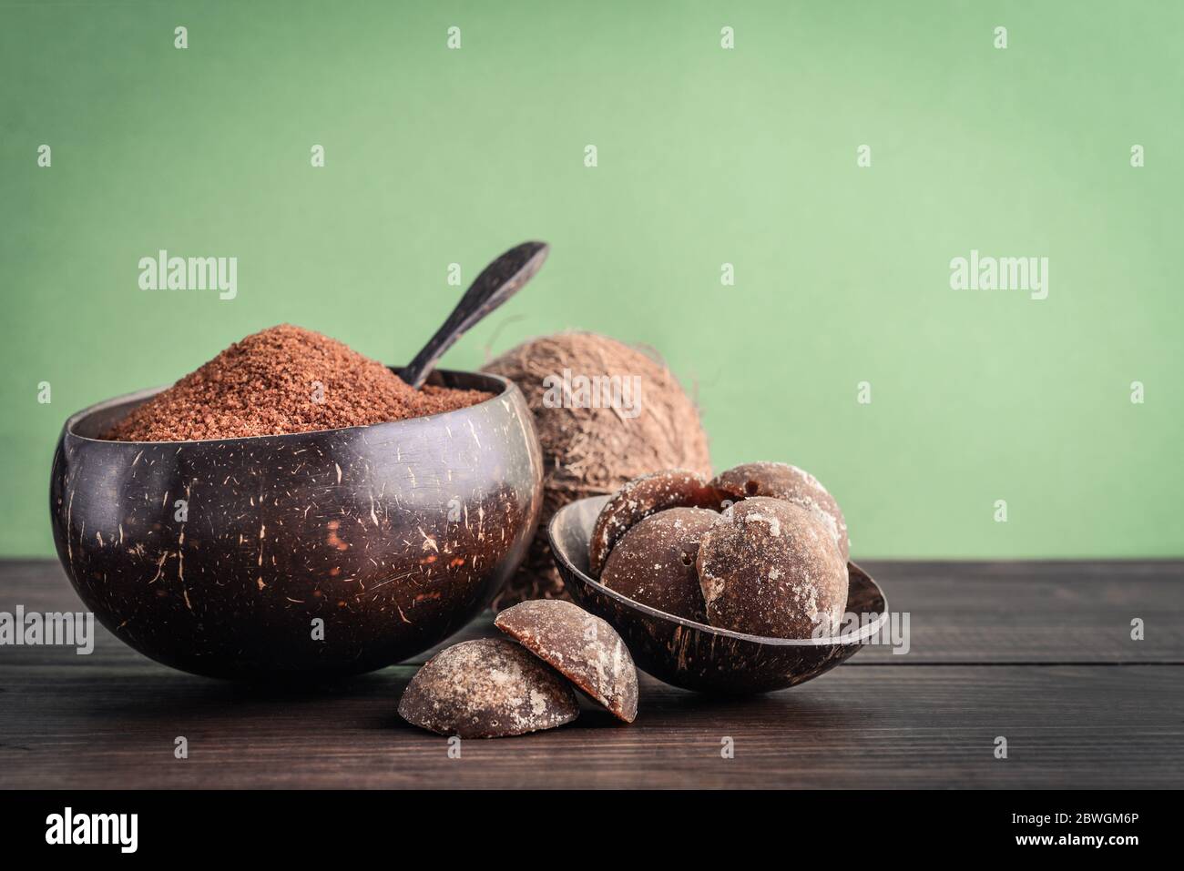 Kokosnuss Palme granulierter Zucker in einer Schüssel mit jaggery Kokosnuss auf Holzhintergrund Nahaufnahme Stockfoto