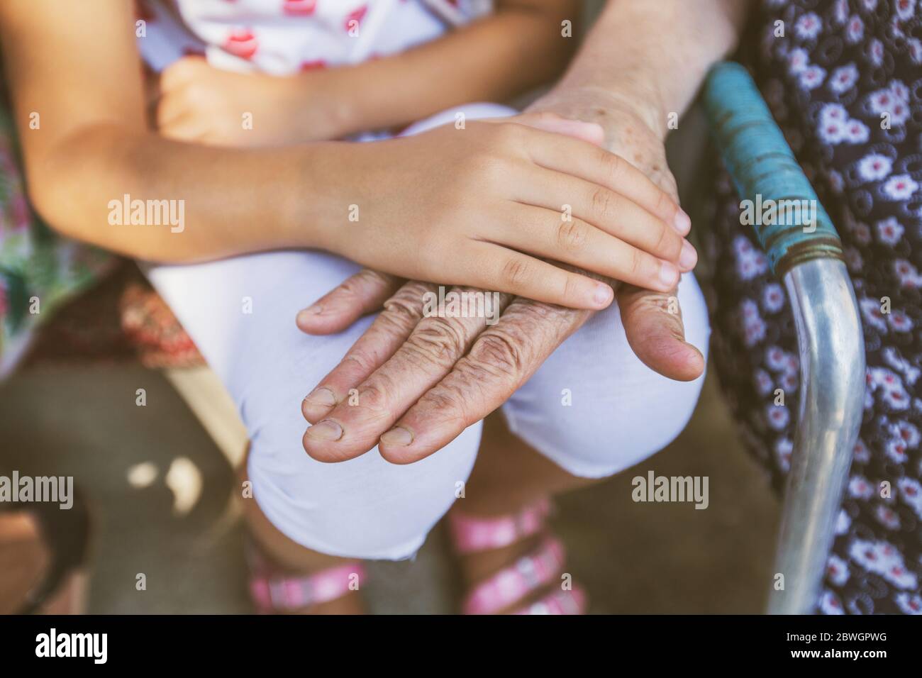 Familienliebe, zwei Generationen, Freundschaft, Kinderhand, Schutz und ältere alte Großmutter Hände vereinen sich Stockfoto
